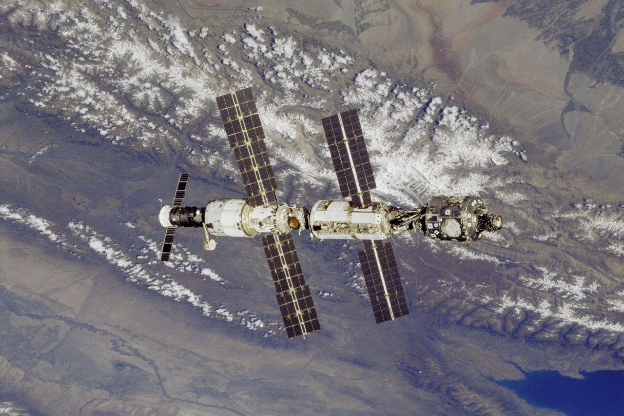 STS106-330-003 (8-20 September 2000)---  The International Space Station (ISS)  is backdropped over mountains and Lake  Issyk-Kul in this 35mm frame, photographed during the fly-around  by the Space Shuttle Atlantis.