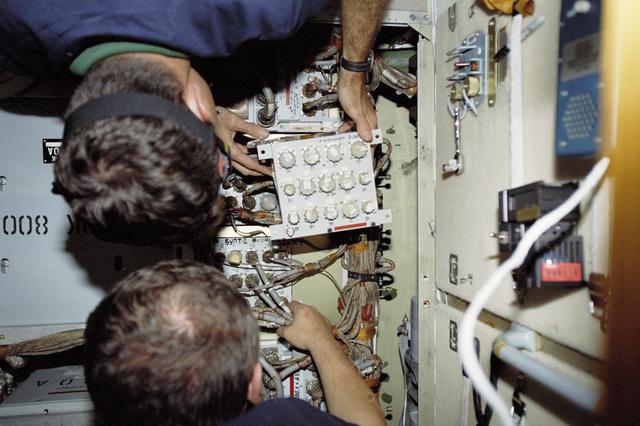 NASA image: Morukov and Burbank work on the storage batteries in Zarya during STS-106