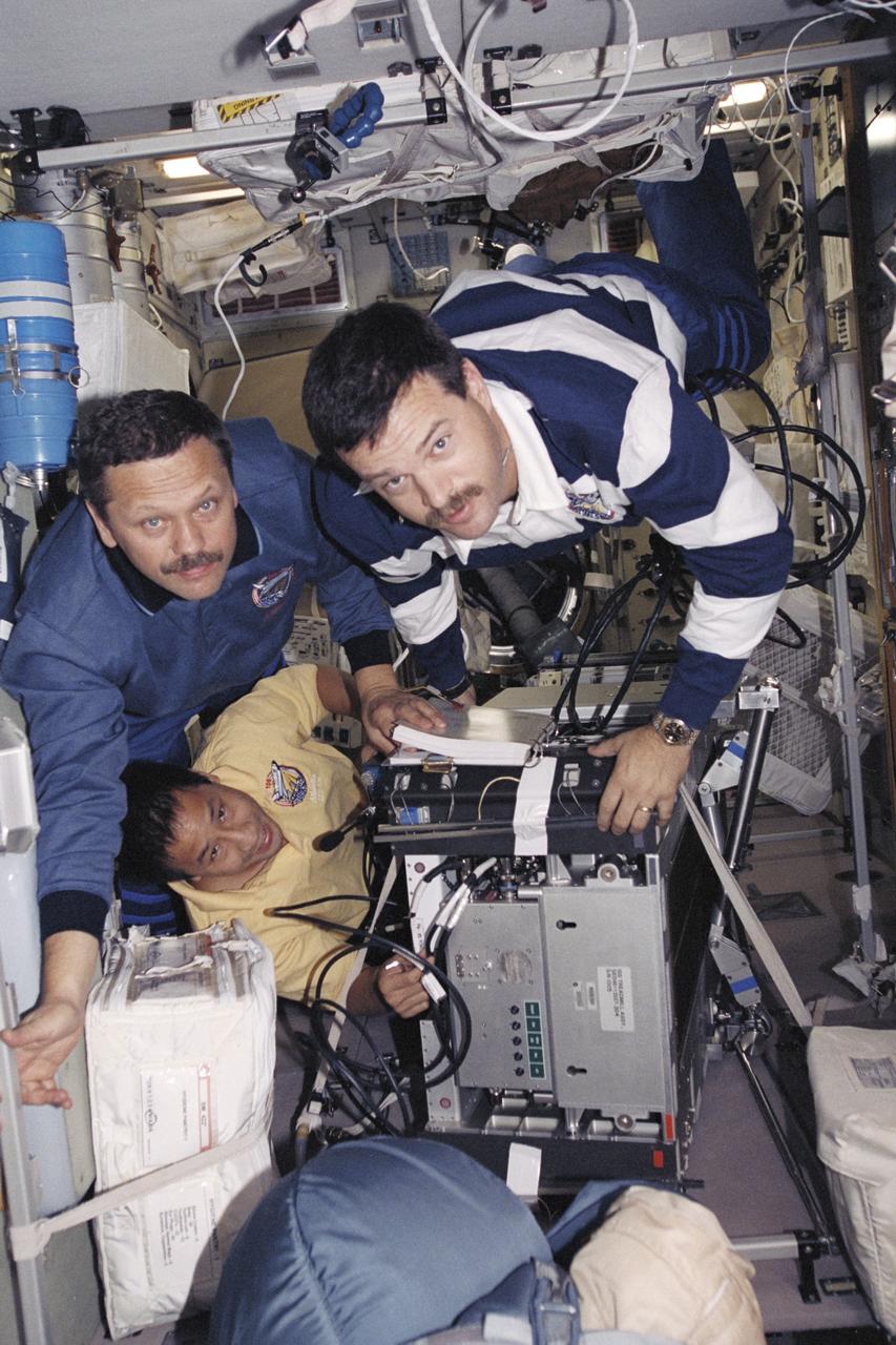 STS106-373-004 (8-20 September 2000) ---  Three members of the STS-106 crew move the treadmill device.  They are (counterclockwise from bottom) astronaut Edward T. Lu and cosmonaut Boris V. Morukov, both mission specialists,  along with astronaut Scott D. Altman, pilot.
