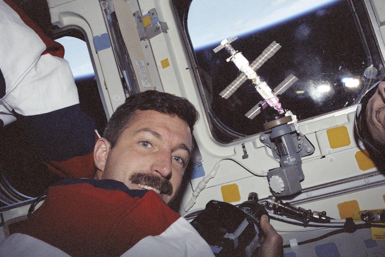 STS106-375-008 (8-20 September 2000) ---  Astronaut Daniel C. Burbank, mission specialist, prepares to photograph the  departing International Space Station through the overhead windows on the aft flight deck of the Space Shuttle Atlantis.