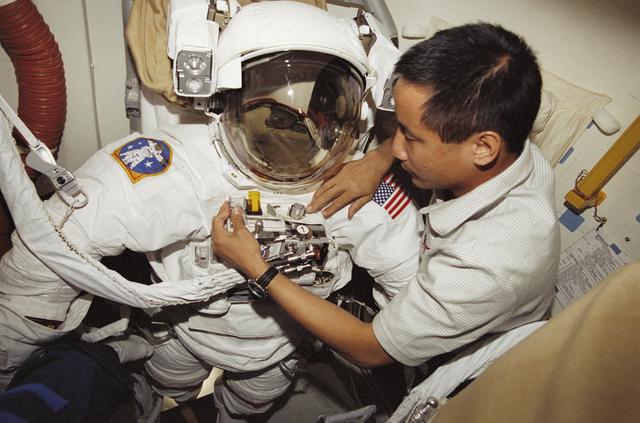 NASA image: MS Lu examines his EMU in the airlock during STS-106