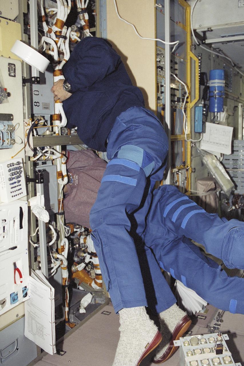 STS106-388-011 (8-20 September 2000) --- Cosmonaut Yuri I. Malenchenko (top), and astronaut Edward T. Lu, both mission specialists, work inside panels in the Zvezda Service Module on the International Space Station (ISS). Malenchenko represents Rosaviakosmos.