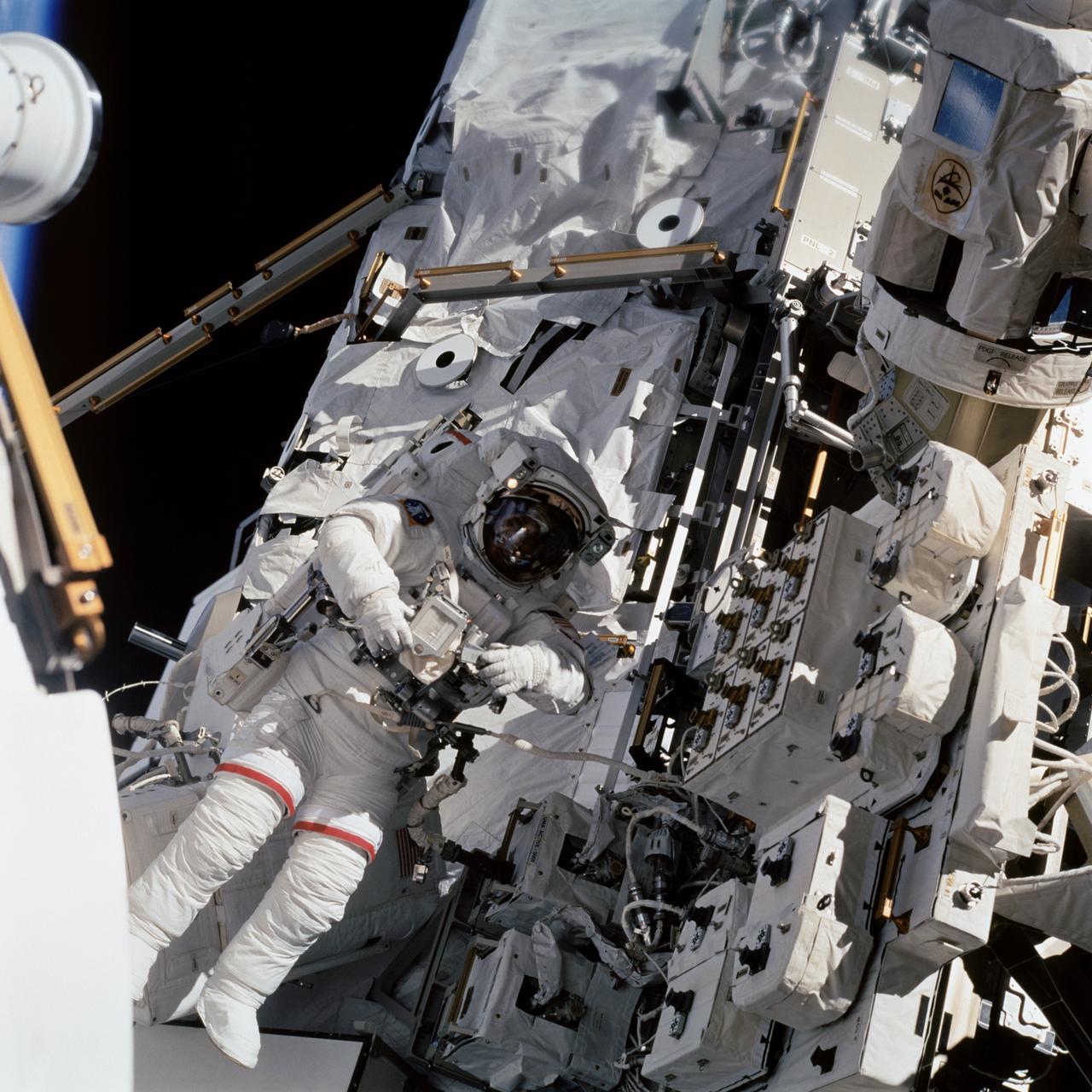 STS112-708-091 (14 October 2002) --- Astronaut David A. Wolf, STS-112 mission specialist, works near the S0 (S-Zero) Truss on the International Space Station (ISS) during the mission’s third and final scheduled session of extravehicular activity (EVA). The airlock spur, a route used by spacewalkers to get from the Quest airlock on the station to the outpost's truss, is visible in the upper left portion of the frame.