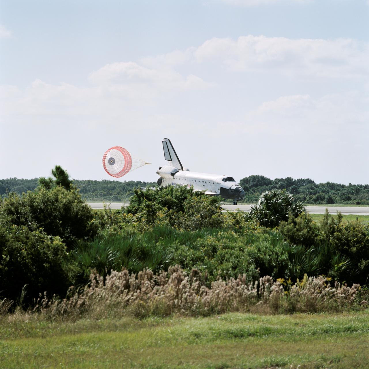 STS112-S-039  (18 October 2002) ---  The drag chute of the Space Shuttle Atlantis helps to slow the vehicle following its touchdown at the Shuttle Landing Facility, completing the 4.5-million-mile journey to the International Space Station. Main gear touchdown occurred at 11:43:40 a.m. EDT; nose gear touchdown at 11:43:48 a.m.; and wheel stop at 11:44:35 a.m. Mission elapsed time  was 10:19:58:44. Mission STS-112 expanded the size of the Station with the addition of the S1 truss segment. The returning crew of Atlantis are  Jeffrey S. Ashby, commander;  Pamela A. Melroy, pilot;  and  David A. Wolf, Piers J. Sellers, Sandra H. Magnus and Rosaviakosmos' Fyodor N. Yurchikhin, all mission specialists. This landing is the 60th at KSC in the 21-year history of the Shuttle program.