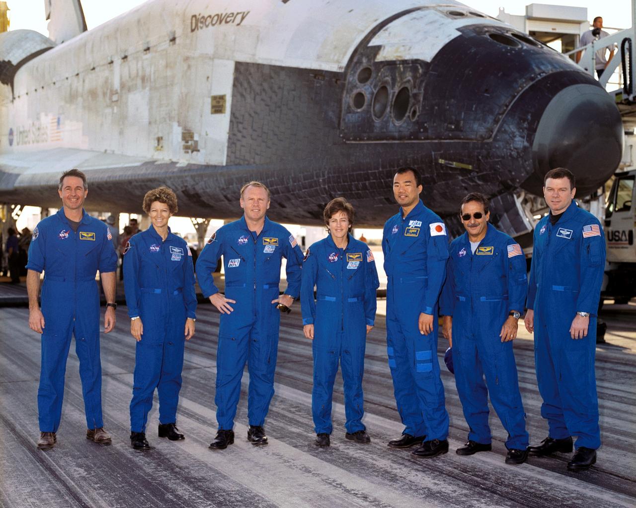STS114-S-045 (9 August 2005) --- The STS-114 crewmembers gather for a crew photo in front of the Space Shuttle Discovery following landing at Edwards Air Force Base in California. From the left are astronauts Stephen K. Robinson, mission specialist; Eileen M. Collins, commander; Andrew S. W. Thomas, Wendy B. Lawrence, Soichi Noguchi representing Japan Aerospace Exploration Agency (JAXA), Charles J. Camarda, all mission specialists; and James M. Kelly, pilot. The landing concludes a historic 14-day, Return to Flight mission to the international space station.