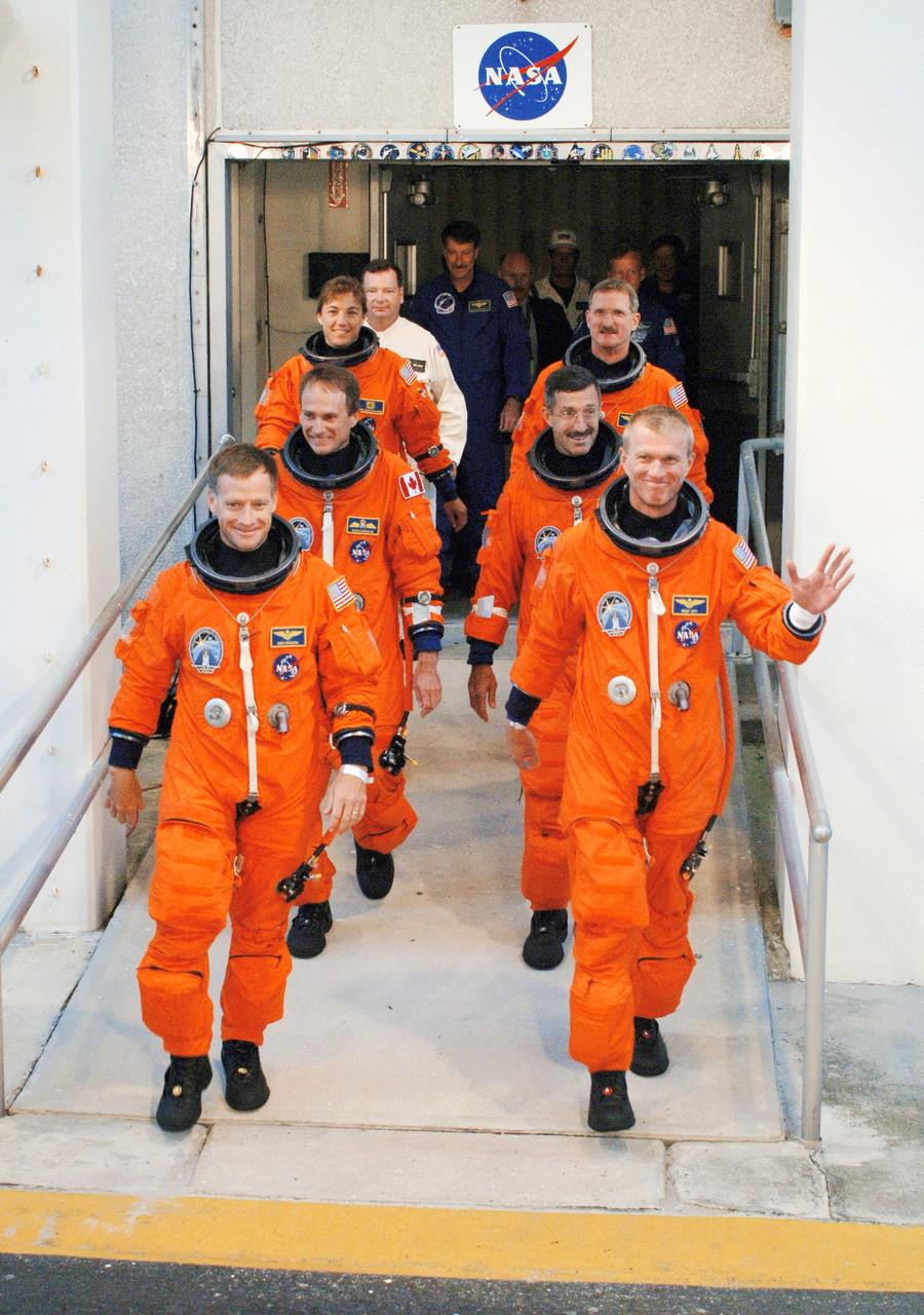 STS115-S-007 (9 Sept. 2006) --- After suiting up, the STS-115 crewmembers exit the Operations and Checkout Building to board the Astrovan, which will take them to launch pad 39B at Kennedy Space Center. On the right (front to back) are astronauts Brent W. Jett, Jr., commander; Daniel C. Burbank and Joseph R. Tanner, both mission specialists. On the left (front to back) are astronauts Christopher J. Ferguson, pilot; Steven G. MacLean representing the Canadian Space Agency and Heidemarie M. Stefanyshyn-Piper, both mission specialists. During the STS-115 mission, Atlantis' astronauts will deliver and install the 17.5-ton, bus-sized P3/P4 integrated truss segment on the station. The girder-like truss includes a set of giant solar arrays, batteries and associated electronics and will provide one-fourth of the total power-generation capability for the completed station.