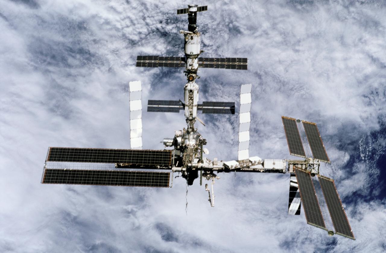 STS116-303-031 (19 Dec. 2006) --- Backdropped by a cloud-covered Earth, the International Space Station moves away from Space Shuttle Discovery. Earlier the STS-116 and Expedition 14 crews concluded eight days of cooperative work onboard the shuttle and station. Undocking of the two spacecraft occurred at 4:10 p.m. (CST) on Dec. 19, 2006. Astronaut William A. (Bill) Oefelein, STS-116 pilot, was at the controls during the fly-around, which gave Discovery's crew a look at its handiwork, a new P5 spacer truss segment and a fully retracted P6 solar array wing. During their stay on orbital outpost, the combined crew installed the newest piece of the station's backbone and completely rewired the power grid over the course of four spacewalks. This image was recorded with a 35mm film-equipped camera.