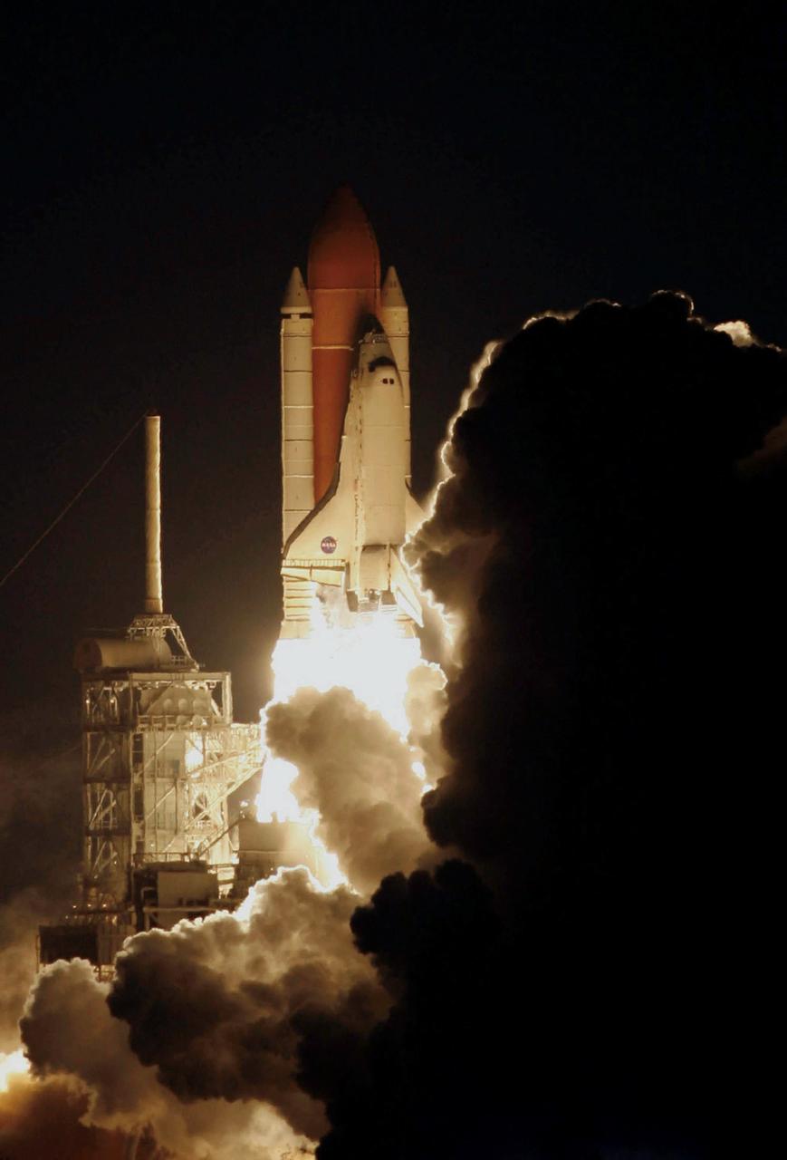 STS116-S-011 (9 Dec. 2006) --- Against a black night sky, the Space Shuttle Discovery and its seven-member crew head toward Earth-orbit and a scheduled link-up with the International Space Station. Liftoff from the Kennedy Space Center's launch pad 39B occurred at 8:47 p.m. (EST) on Dec. 9, 2006 in what was the first evening shuttle launch since 2002. The STS-116 crew will link up with the station on Monday, Dec. 11, to begin a complex, week-long stay that will rewire the outpost and increase its power supply. During three spacewalks and intricate choreography with ground controllers, the astronauts will bring electrical power on line generated by a giant solar array wing delivered to the station in September.