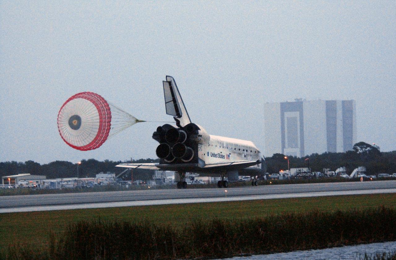 STS116-S-070 (22 Dec. 2006) --- Discovery's drag chute is fully deployed as the spacecraft rolls toward wheels stop on Runway 15 at NASA Kennedy Space Center's Shuttle Landing Facility , concluding mission STS-116. The Vehicle Assembly Building can be seen at far right. Aboard are astronauts Mark L. Polansky, commander; William A. Oefelein, pilot; and Robert L. Curbeam Jr., Joan E. Higginbotham, Nicholas J.M. Patrick and European Space Agency astronauts Christer Fuglesang and Thomas Reiter--all mission specialists. Reiter is returning from a six-month stay on the International Space Station. During the mission, three spacewalks attached the P5 integrated truss structure to the station, and completed the rewiring of the orbiting laboratory's power system. A contingency spacewalk was added to retract a stubborn solar array. Main gear touchdown was at 5:32 p.m. (EST). Nose gear touchdown was at 5:32:12 p.m. and wheel stop was at 5:32:52 p.m. At touchdown -- nominally about 2,500 ft. beyond the runway threshold -- the orbiter is traveling at a speed ranging from 213 to 226 mph. Discovery traveled 5,330,000 miles, landing on orbit 204. Mission elapsed time was 12 days, 20 hours, 44 minutes and 16 seconds. This is the 64th landing at KSC.