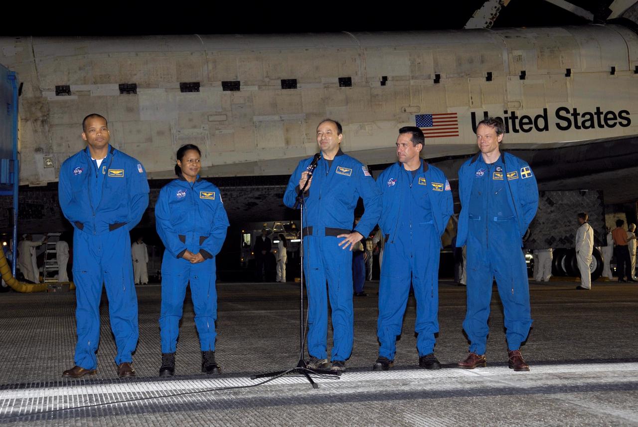 STS116-S-073 (22 Dec. 2006) --- Following the successful completion of a 13-day mission on Runway 15 at NASA Kennedy Space Center's Shuttle Landing Facility, crewmembers address those on hand to greet them. Mark L. Polansky, commander, stands at the microphone. William A. Oefelein, pilot, is at second right. Others, from the left, are astronauts Robert L. Curbeam Jr., Joan E. Higginbotham and European Space Agency astronaut Christer Fuglesang--all mission specialists. ESA astronaut Thomas Reiter, who is returning from a six-month stay on the International Space Station, and astronaut Nicholas J.M. Patrick, a mission specialist, are not pictured. During the mission, three spacewalks attached the P5 integrated truss structure to the station, and completed the rewiring of the orbiting laboratory's power system. A contingency spacewalk was added to retract a stubborn solar array. Main gear touchdown was at 5:32 p.m. (EST). Nose gear touchdown was at 5:32:12 p.m. and wheel stop was at 5:32:52 p.m. At touchdown -- nominally about 2,500 ft. beyond the runway threshold -- the orbiter is traveling at a speed ranging from 213 to 226 mph. Discovery traveled 5,330,000 miles, landing on orbit 204. Mission elapsed time was 12 days, 20 hours, 44 minutes and 16 seconds. This is the 64th landing at KSC.