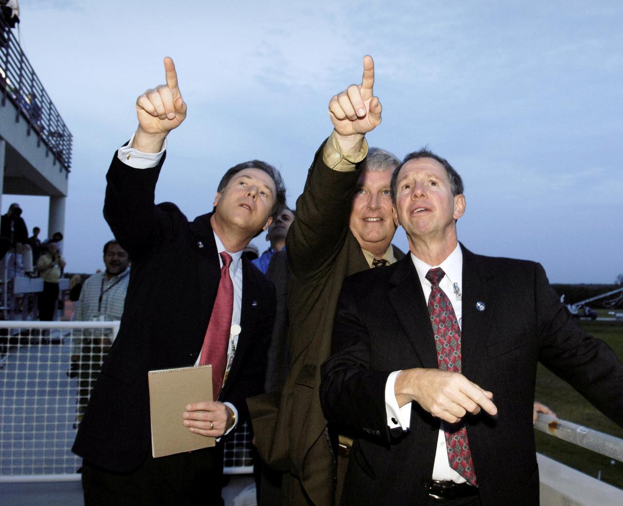 STS116-S-079 (22 Dec. 2006) --- David Mould (left), NASA assistant administrator for Public Affairs, Jim Kennedy (center), director  of  Kennedy Space Center and Michael Griffin, NASA administrator, follow the Space Shuttle Discovery as it approaches Runway 15 at the Shuttle Landing Facility. The STS-116 crew completed its mission at  5:32 p.m. (EST),  Dec. 22. (Photo credit: NASA/Bill Ingalls)
