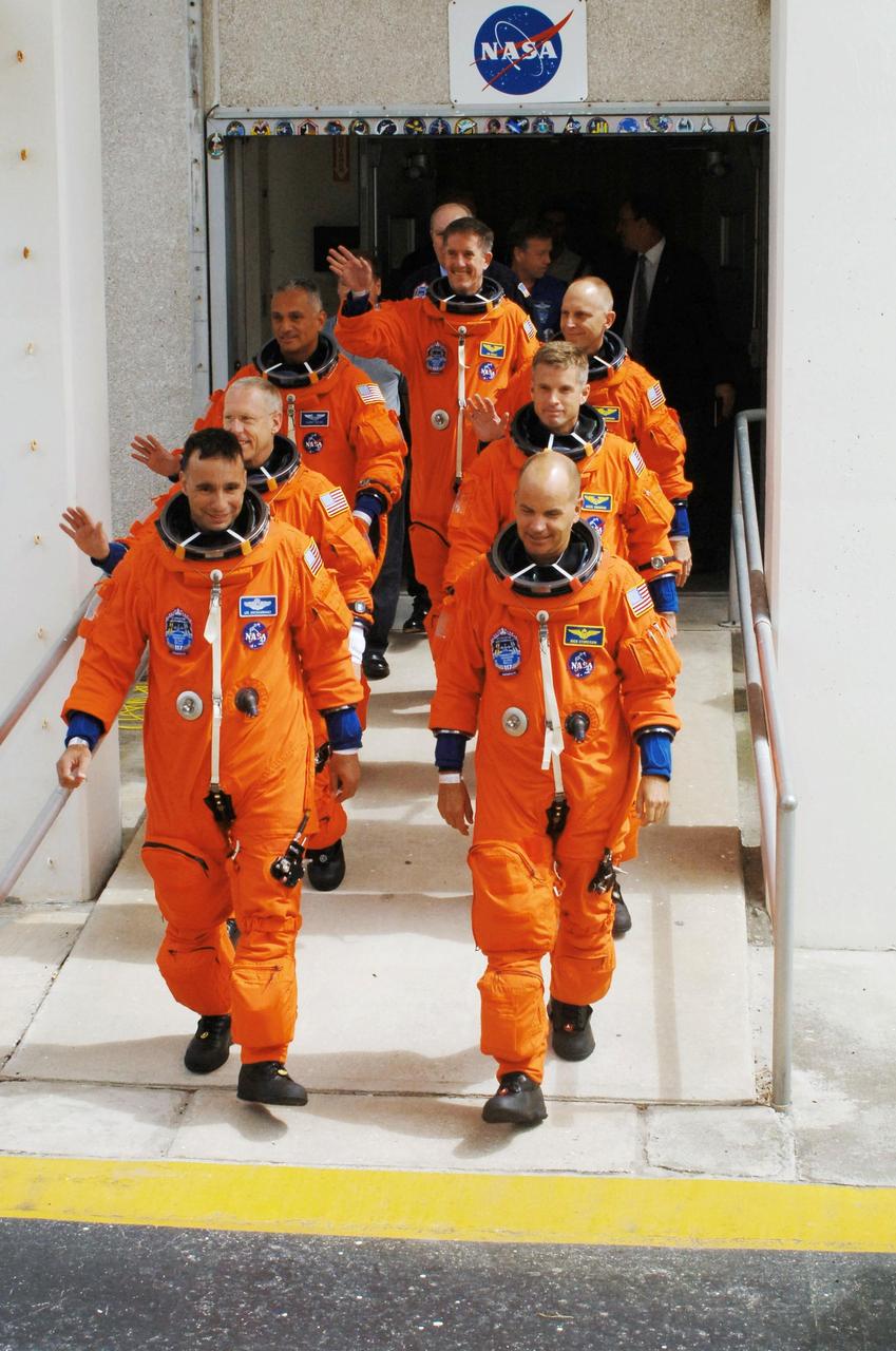 STS117-S-006 (8 June 2007) --- After suiting up, the STS-117 crewmembers exit the Operations and Checkout Building to board the Astrovan, which will take them to launch pad 39A at Kennedy Space Center. On the right (front to back) are astronauts Rick Sturckow, commander; Steven Swanson, Clayton Anderson and Jim Reilly (center back), all mission specialists. On the left (front to back) are astronauts Lee Archambault, pilot; Patrick Forrester and John "Danny" Olivas, both mission specialists. Anderson will join Expedition 15 in progress to serve as a flight engineer aboard the International Space Station. Atlantis will link up with the International Space Station on Sunday, June 10, to begin a joint mission that will increase the complex's power generation capability. Using the shuttle and station robotic arms and conducting three scheduled spacewalks, the astronauts will install another set of giant solar array wings on the station and retract another array, preparing it for a future move.