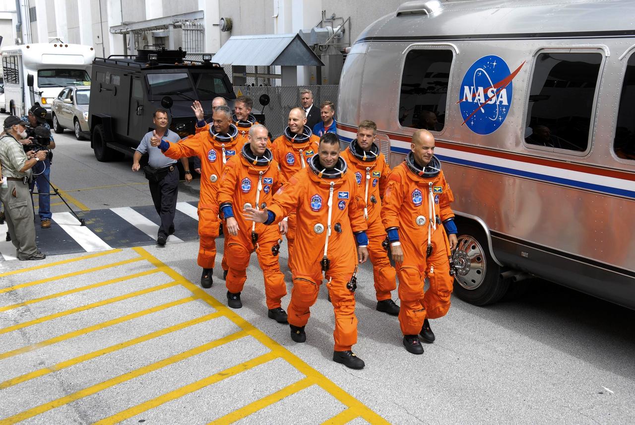 STS117-S-007 (8 June 2007) --- After suiting up, the STS-117 crewmembers exit the Operations and Checkout Building to board the Astrovan, which will take them to launch pad 39A at Kennedy Space Center. On the right (front to back) are astronauts Rick Sturckow, commander; Steven Swanson, Clayton Anderson and Jim Reilly, all mission specialists. On the left (front to back) are astronauts Lee Archambault, pilot; Patrick Forrester and John "Danny" Olivas, both mission specialists. Anderson will join Expedition 15 in progress to serve as a flight engineer aboard the International Space Station. Atlantis will link up with the International Space Station on Sunday, June 10, to begin a joint mission that will increase the complex's power generation capability. Using the shuttle and station robotic arms and conducting three scheduled spacewalks, the astronauts will install another set of giant solar array wings on the station and retract another array, preparing it for a future move.