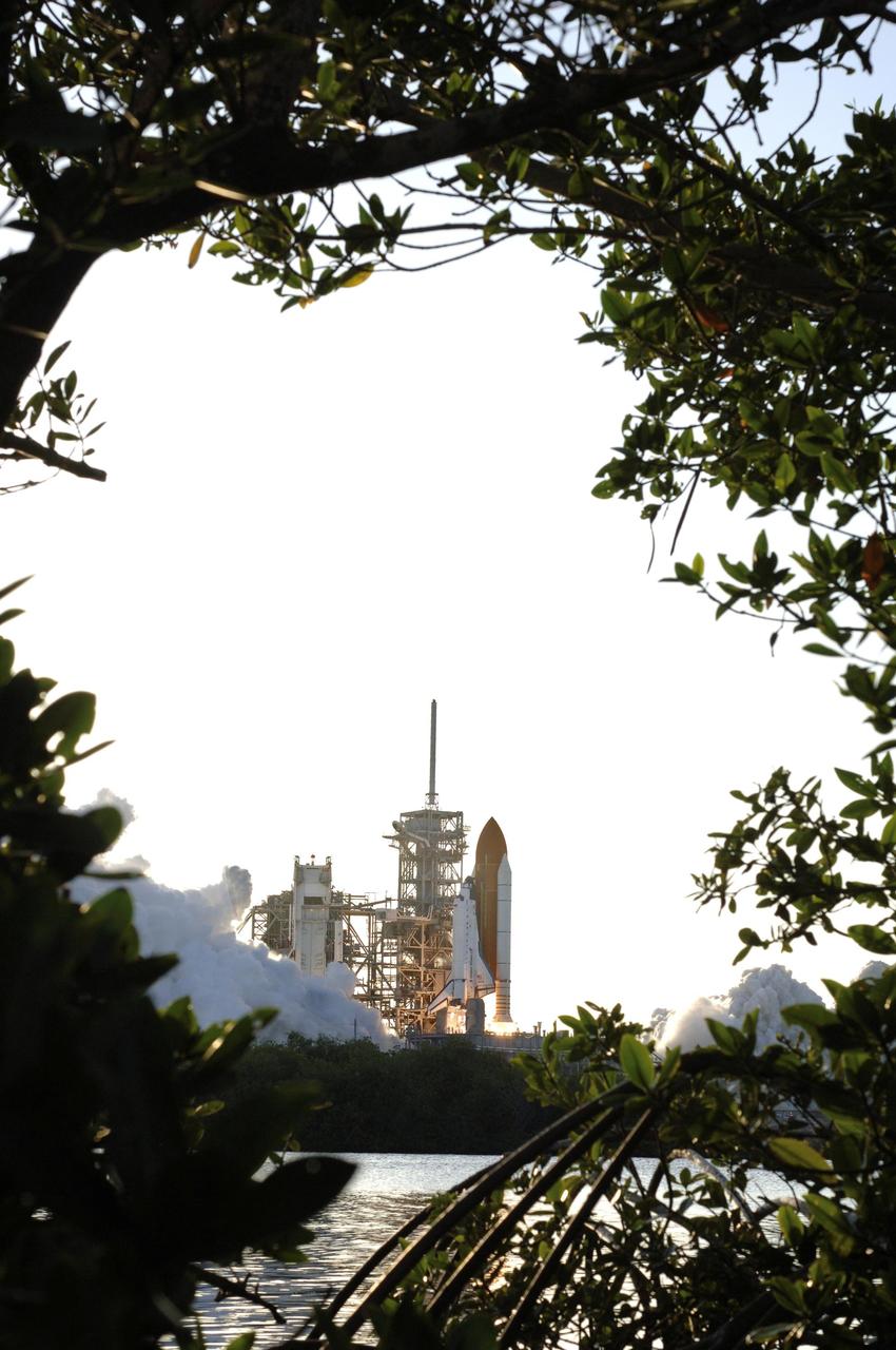 STS117-S-021 (8 June 2007) --- Framed here by Florida foliage, the Space Shuttle Atlantis and its seven-member STS-117 crew head toward Earth-orbit and a scheduled link-up with the International Space Station. Liftoff from Kennedy Space Center's launch pad 39A occurred at 7:38 p.m. (EDT) on June 8, 2007. Onboard are astronauts Rick Sturckow, commander; Lee Archambault, pilot; Jim Reilly, Patrick Forrester, John "Danny" Olivas, Steven Swanson and Clayton Anderson, all mission specialists. Anderson will join Expedition 15 in progress to serve as a flight engineer aboard the station. Atlantis will dock with the orbital outpost on Sunday, June 10, to begin a joint mission that will increase the complex's power generation capability. Using the shuttle and station robotic arms and conducting three scheduled spacewalks, the astronauts will install another set of giant solar array wings on the station and retract another array, preparing it for a future move.