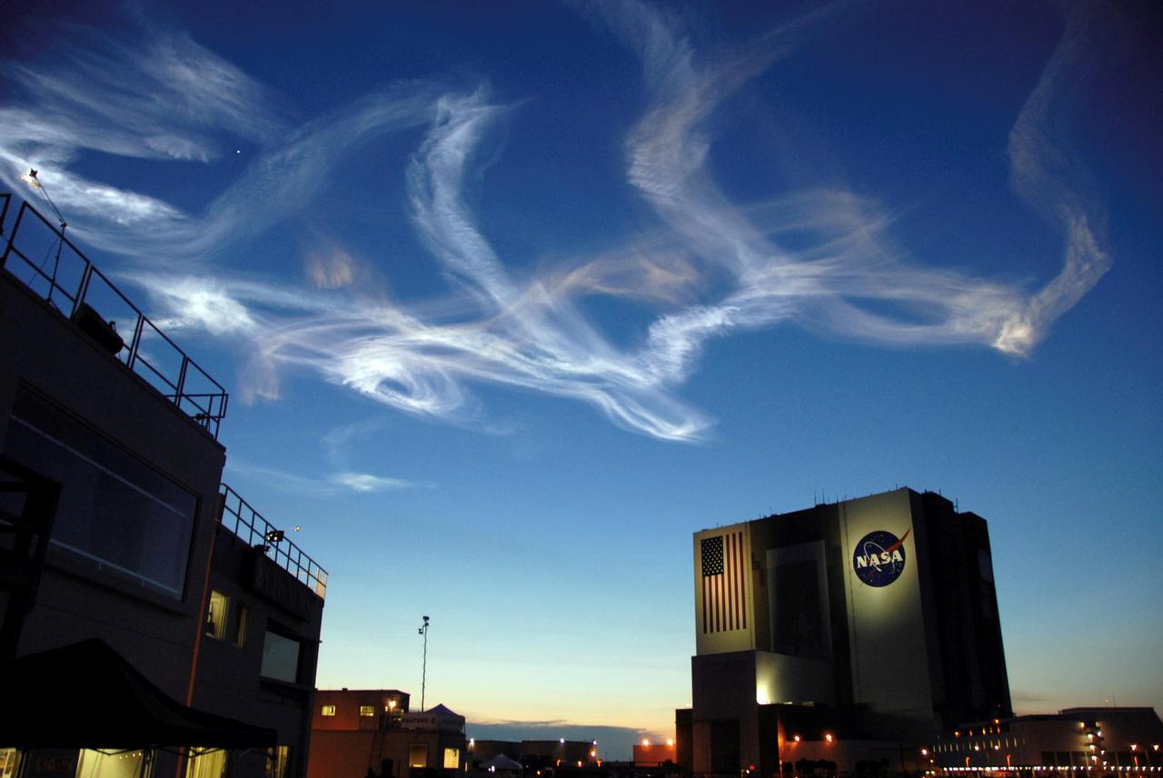 STS117-S-029 (8 June 2007) --- The drifting smoke plumes from the launch of Space Shuttle Atlantis (out of frame) swirl above the Vehicle Assembly Building near sunset. Atlantis and its seven-member STS-117 crew head toward Earth-orbit and a scheduled link-up with the International Space Station. Liftoff from Kennedy Space Center's launch pad 39A occurred at 7:38 p.m. (EDT) on June 8, 2007. Onboard are astronauts Rick Sturckow, commander; Lee Archambault, pilot; Jim Reilly, Patrick Forrester, John "Danny" Olivas, Steven Swanson and Clayton Anderson, all mission specialists. Anderson will join Expedition 15 in progress to serve as a flight engineer aboard the station. Atlantis will dock with the orbital outpost on Sunday, June 10, to begin a joint mission that will increase the complex's power generation capability. Using the shuttle and station robotic arms and conducting three scheduled spacewalks, the astronauts will install another set of giant solar array wings on the station and retract another array, preparing it for a future move.