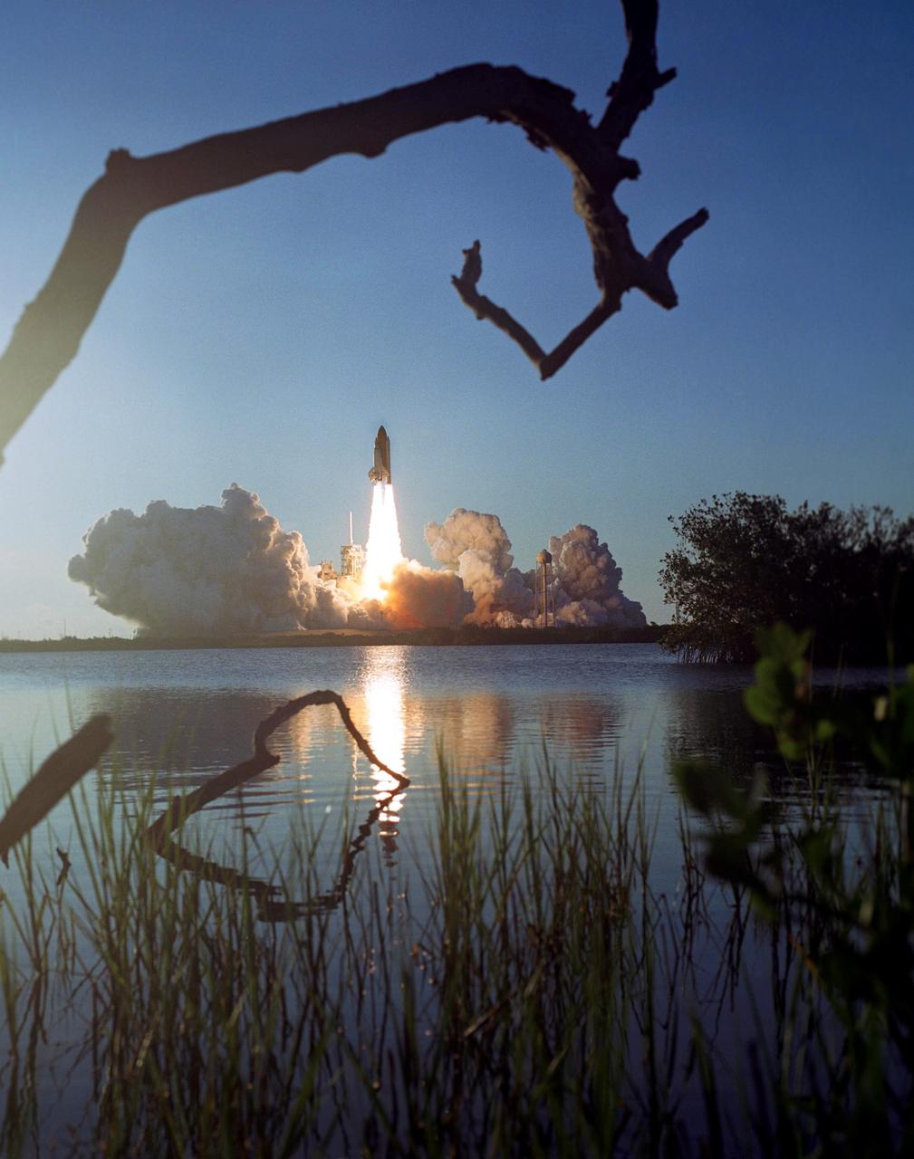 STS117-S-032 (8 June 2007) --- Framed here by branches, the Space Shuttle Atlantis and its seven-member STS-117 crew head toward Earth-orbit and a scheduled link-up with the International Space Station. Liftoff from Kennedy Space Center's launch pad 39A occurred at 7:38 p.m. (EDT) on June 8, 2007. Onboard are astronauts Rick Sturckow, commander; Lee Archambault, pilot; Jim Reilly, Patrick Forrester, John "Danny" Olivas, Steven Swanson and Clayton Anderson, all mission specialists. Anderson will join Expedition 15 in progress to serve as a flight engineer aboard the station. Atlantis will dock with the orbital outpost on Sunday, June 10, to begin a joint mission that will increase the complex's power generation capability. Using the shuttle and station robotic arms and conducting three scheduled spacewalks, the astronauts will install another set of giant solar array wings on the station and retract another array, preparing it for a future move.