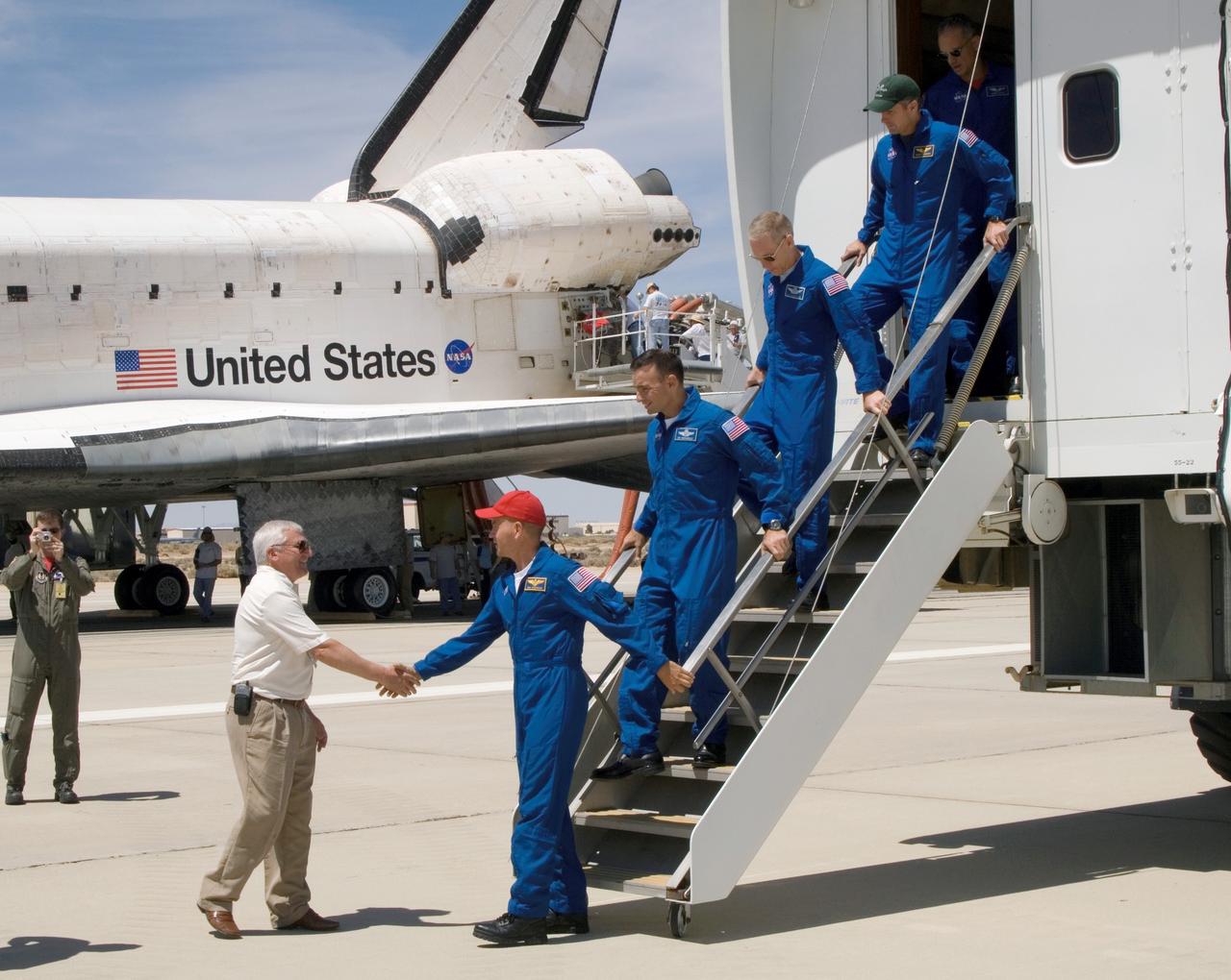 STS117-S-051 (22 June 2007) --- NASA Dryden Flight Research Center director Kevin Petersen greets astronaut Rick Sturckow, STS-117 commander, as the crewmembers exit NASA's Crew Transport Vehicle (CTV) after a successful landing at 12:49 p.m. (PDT) on June 22, 2007 at Edwards Air Force Base in California. Following behind Sturckow are astronauts Lee Archambault, pilot; Patrick Forrester, Steven Swanson and John "Danny" Olivas, all mission specialists. Not pictured is astronaut Jim Reilly, mission specialist.