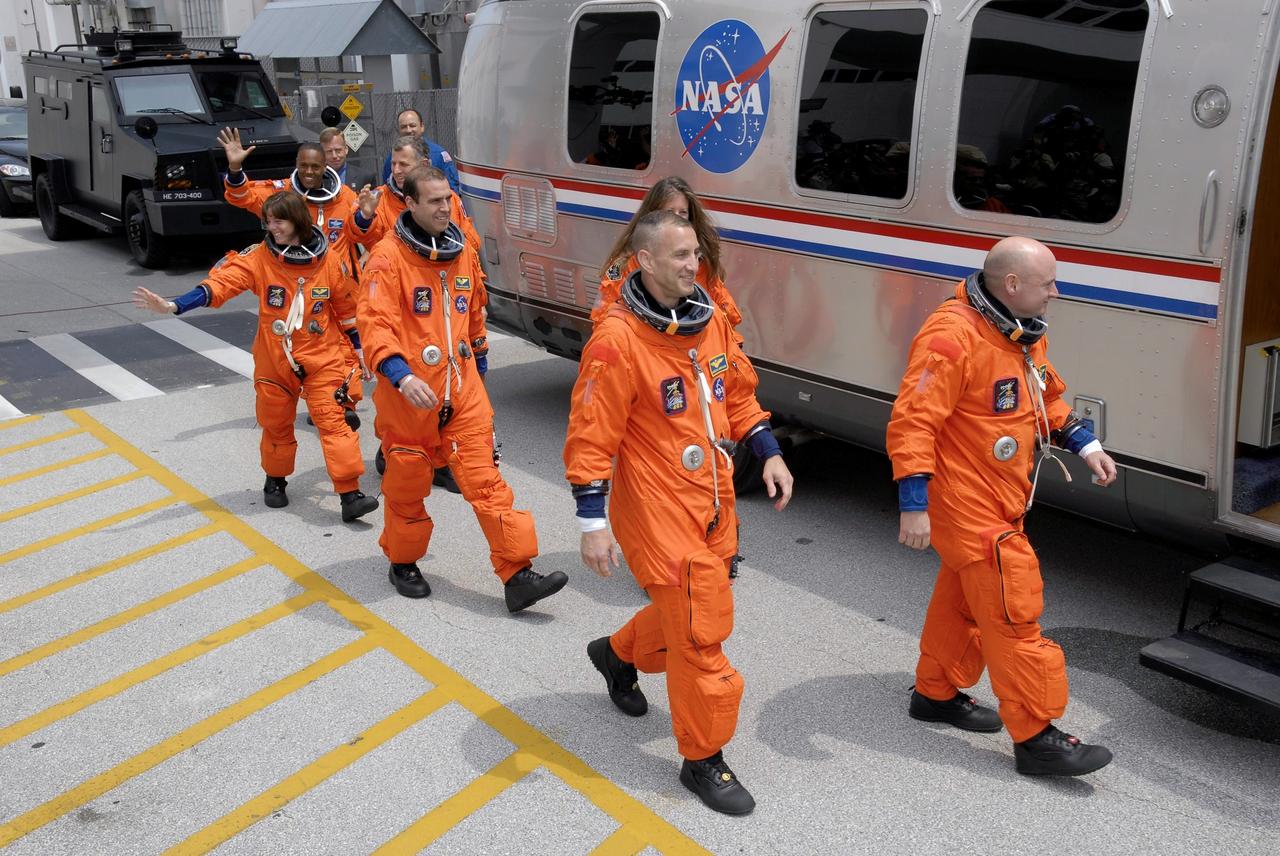STS118-S-008 (8 Aug. 2007) --- After suiting up, the STS-118 crewmembers exit the Operations and Checkout Building to board the Astrovan, which will take them to launch pad 39A at Kennedy Space Center. Pictured from the right are astronauts Scott Kelly, commander; Charlie Hobaugh, pilot; Tracy Caldwell, Rick Mastracchio, Canadian Space Agency's Dave Williams, Barbara R. Morgan and Alvin Drew, all mission specialists. Endeavour will link up with the International Space Station on Friday, Aug. 10, to begin a joint mission to continue construction by delivering a third starboard truss segment, S5, and other payloads such as the SPACEHAB module and the external stowage platform 3. The 11-day mission may be extended to as many as 14 depending on the test of the Station-to-Shuttle Power Transfer System that will allow the docked shuttle to draw electrical power from the station and extend its visits to the orbital complex.