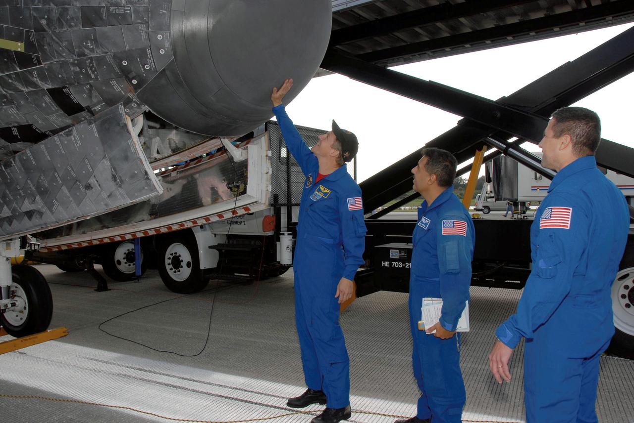 STS120-S-092 (7 Nov. 2007) --- Astronaut Scott Parazynski, STS-120 mission specialist, touches the nose cone of Space Shuttle Discovery after its landing at NASA's Kennedy Space Center. At far right is astronaut George Zamka, STS-120 pilot, and at center is astronaut Jose Hernandez. The crew is taking part in the traditional walkdown to look at the state of the shuttle after a launch and landing. The Discovery crew completed the 15-day STS-120 mission, with an on-time landing at 1:01:16 p.m. (EST). Wheel stop was at 1:02:07 p.m. Mission elapsed time was 15 days, 2 hours, 24 minutes and 2 seconds. The STS-120 crew continued the construction of the station with the installation of the Harmony Node 2 module and the relocation of the P6 truss.