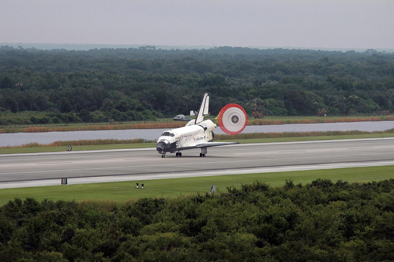STS121-S-056 (17 July 2006) --- With drag chute deployed, Space Shuttle Discovery slows to a stop after landing on runway 15 at Kennedy Space Center's Shuttle Landing Facility at 9:14 a.m. (EDT) on July 17, 2006. Onboard were astronauts Steven W. Lindsey, commander; Mark E. Kelly, pilot; Piers J. Sellers, Michael E. Fossum, Lisa M. Nowak and Stephanie D. Wilson, all mission specialists. During the nearly 13-day mission, the STS-121 crew tested new equipment and procedures to improve shuttle safety, and delivered supplies and made repairs to the International Space Station.