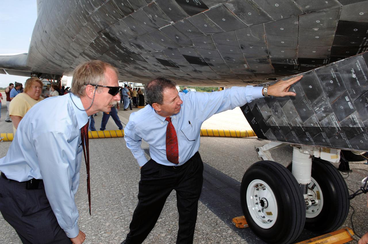 STS121-S-064 (17 July 2006) --- Dr. Michael Griffin (right), NASA administrator; and William H. Gerstenmaier, associate administrator for Space Operations, inspect the Space Shuttle Discovery after the landing and conclusion of mission STS-121. The crew of seven tested new equipment and procedures to improve shuttle safety, as well as deliver supplies and make repairs to the International Space Station. Photo Credit: NASA/Bill Ingalls