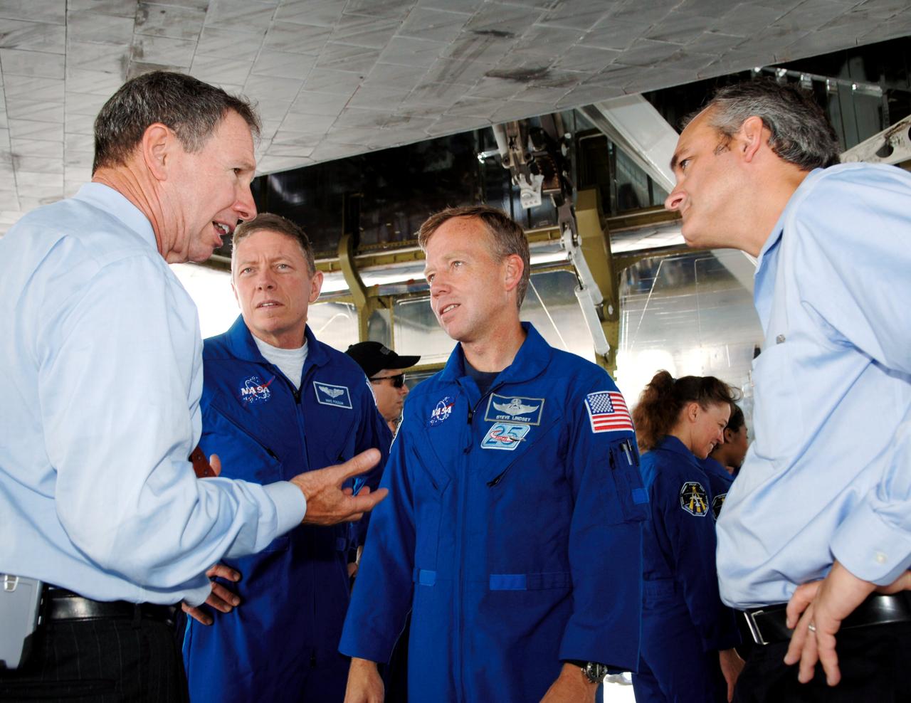 STS121-S-066 (17 July 2006) --- Dr. Michael Griffin (left), NASA administrator, and Rex Geveden (right), associate administrator, talk with STS-121 crew members Michael E. Fossum (left), mission specialist; and Steven W. Lindsey, commander, after the landing of the Space Shuttle Discovery and conclusion of mission STS-121. The crew of seven tested new equipment and procedures to improve shuttle safety, as well as deliver supplies and make repairs to the International Space Station. Photo Credit: NASA/Bill Ingalls