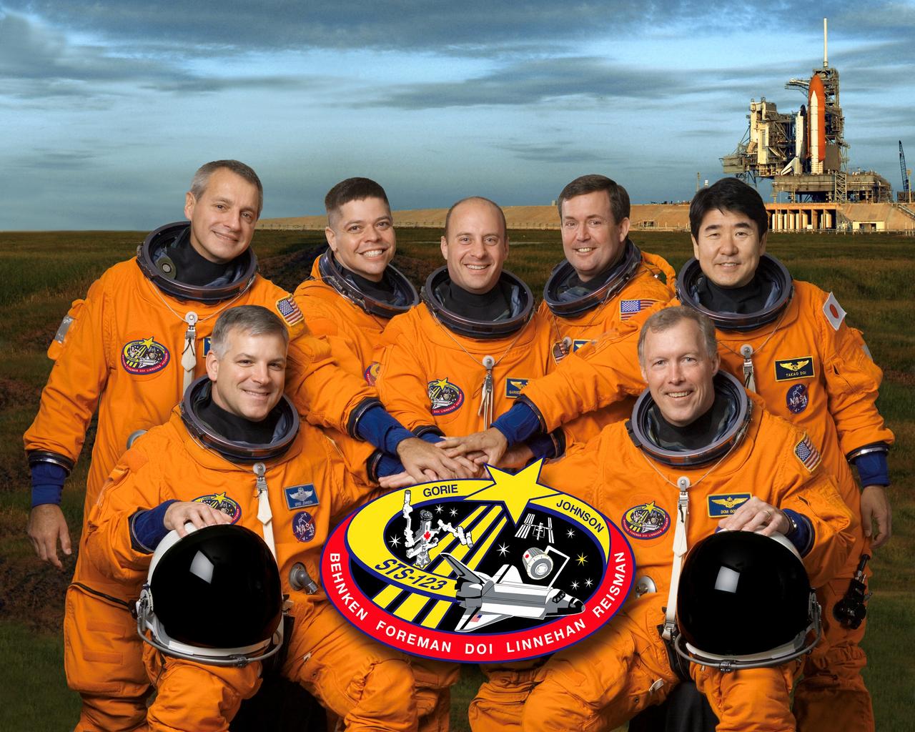 STS123-S-002 (26 July 2007) --- These seven astronauts take a break from training to pose for the STS-123 crew portrait. From the right (front row) are astronauts Dominic L. Gorie, commander; and Gregory H. Johnson, pilot. From the left (back row) are astronauts Richard M. Linnehan, Robert L. Behnken, Garrett E. Reisman, Michael J. Foreman and Japan Aerospace Exploration Agency's (JAXA) Takao Doi, all mission specialists. Reisman is scheduled to join Expedition 16 as flight engineer after launching to the International Space Station on mission STS-123. The crewmembers are attired in training versions of their shuttle launch and entry suits.