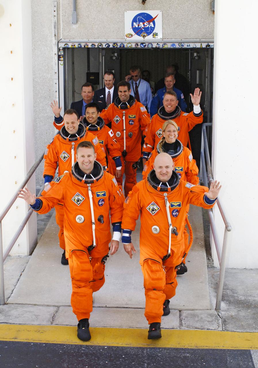 STS124-S-005 (31 May 2008) --- After suiting up, the STS-124 crewmembers exit the Operations and Checkout Building to board the Astrovan, which will take them to launch pad 39A for the launch of Space Shuttle Discovery on the STS-124 mission. On the right (front to back) are astronauts Mark Kelly, commander; Karen Nyberg and Mike Fossum, both mission specialists. On the left (front to back) are astronauts Ken Ham, pilot; Ron Garan, Japan Aerospace Exploration Agency (JAXA) astronaut Akihiko Hoshide and Greg Chamitoff, all mission specialists. The STS-124 mission is the 26th in the assembly of the International Space Station. It is the second of three flights launching components to complete JAXA's Kibo laboratory. During the mission, the shuttle crew will install Kibo's large Japanese Pressurized Module and its remote manipulator system. Chamitoff will join Expedition 17 in progress to serve as a flight engineer aboard the station.