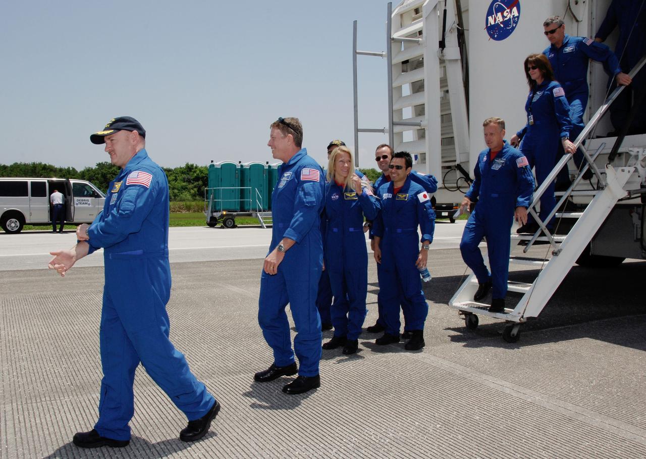 STS124-S-076 (14 June 2008) --- After their successful STS-124 mission and landing on runway 15 at NASA's Kennedy Space Center, crewmembers exit the crew transport vehicle. Leading the way is NASA astronaut Mark Kelly, commander; followed by (from the left) Mike Fossum, Karen Nyberg, Japan Aerospace Exploration Agency astronaut Akihiko Hoshide and NASA astronaut Ron Garan, all mission specialists. Behind them is Stephen Lindsey, chief of the astronaut office, and astronaut Janet Kavandi. Space Shuttle Discovery's main landing gear touched down at 11:15:19 a.m. (EDT) on June 14, 2008. The nose landing gear touched down at 11:15:30 a.m. and wheel stop was at 11:16:19 a.m. During the mission, Discovery's crew installed the Japan Aerospace Exploration Agency's large Kibo laboratory and its remote manipulator system leaving a larger space station and one with increased science capabilities.
