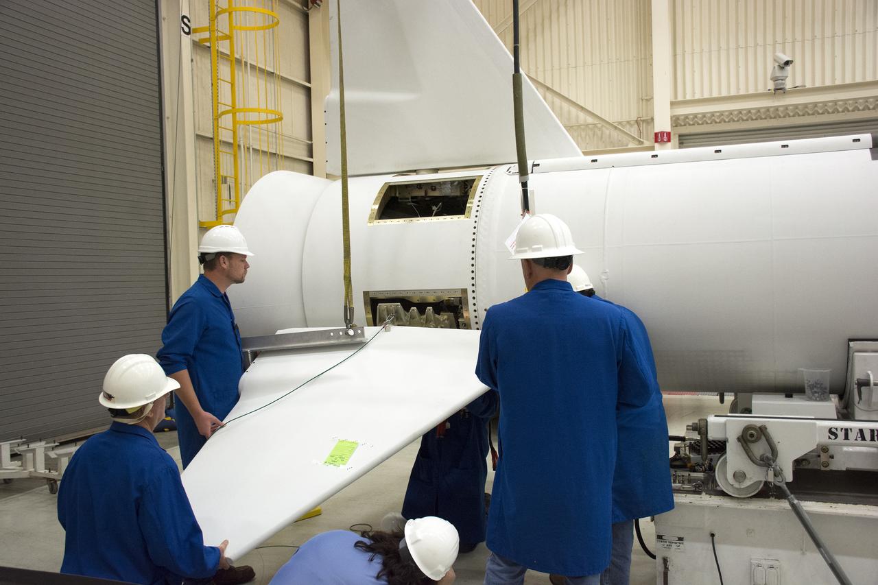 Technicians prepare to install one of the fins on the Orbital ATK Pegasus XL rocket inside Building 1555 at Vandenberg Air Force Base in California. The fins will provide aerodynamic stability during flight. The rocket is being prepared at Vandenberg, and then will be transported to NASA’s Kennedy Space Center in Florida attached to the Orbital ATK L-1011 carrier aircraft with NASA’s Cyclone Global Navigation Satellite System (CYGNSS) in its payload fairing. CYGNSS will launch on the Pegasus XL rocket from the Skid Strip at Cape Canaveral Air Force Station. CYGNSS will make frequent and accurate measurements of ocean surface winds throughout the life cycle of tropical storms and hurricanes. The data that CYGNSS provides will enable scientists to probe key air-sea interaction processes that take place near the core of storms, which are rapidly changing and play a critical role in the beginning and intensification of hurricanes. 