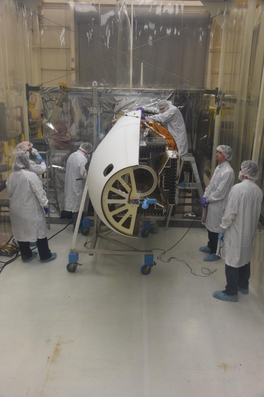 Technicians with Orbital ATK install the first half of the Pegasus XL fairing around NASA’s Cyclone Global Navigation Satellite System (CYGNSS) in Building 1555 at Vandenberg Air Force Base in California. CYGNSS is being prepared at Vandenberg, and then will be transported to NASA’s Kennedy Space Center in Florida aboard the Orbital ATK Pegasus XL rocket which will be attached to the Orbital ATK L-1011 carrier aircraft. CYGNSS will launch on the Pegasus XL rocket from the Skid Strip at Cape Canaveral Air Force Station. CYGNSS will make frequent and accurate measurements of ocean surface winds throughout the life cycle of tropical storms and hurricanes. The data that CYGNSS provides will enable scientists to probe key air-sea interaction processes that take place near the core of storms, which are rapidly changing and play a critical role in the beginning and intensification of hurricanes.