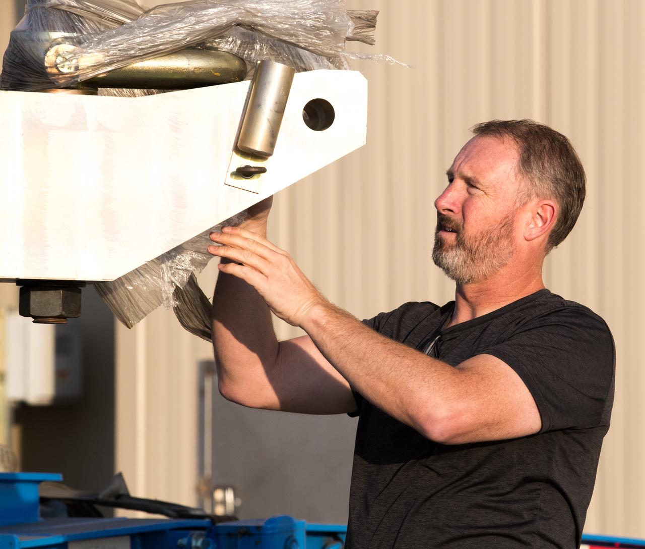 A technician at Vandenberg Air Force Base in California inspects the shipping container for the Joint Polar Satellite System-1, or JPSS-1, as it arrives at the Astrotech Processing Facility. JPSS is the first in a series four next-generation environmental satellites in a collaborative program between the National Oceanic and Atmospheric Administration (NOAA) and NASA. The satellite is scheduled to liftoff Nov. 10, 2017 atop a United Launch Alliance Delta II rocket.