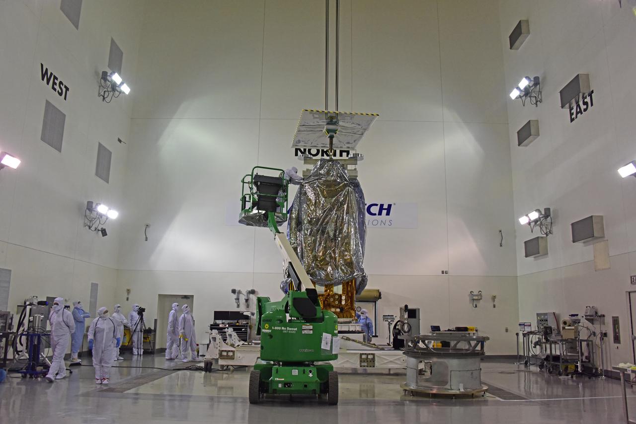 NOAA's Joint Polar Satellite System-1, or JPSS-1, remains wrapped in a protective covering after removal from its shipping container at the Astrotech Processing Facility at Vandenberg Air Force Base in California. A crane is attached to the spacecraft to prepare for its move to a payload attach fitting. JPSS-1 will liftoff aboard a United Launch Alliance Delta II rocket from Vandenberg's Space Launch Complex-2. JPSS-1 is the first in a series of four next-generation environmental satellites in a collaborative program between NOAA and NASA. 