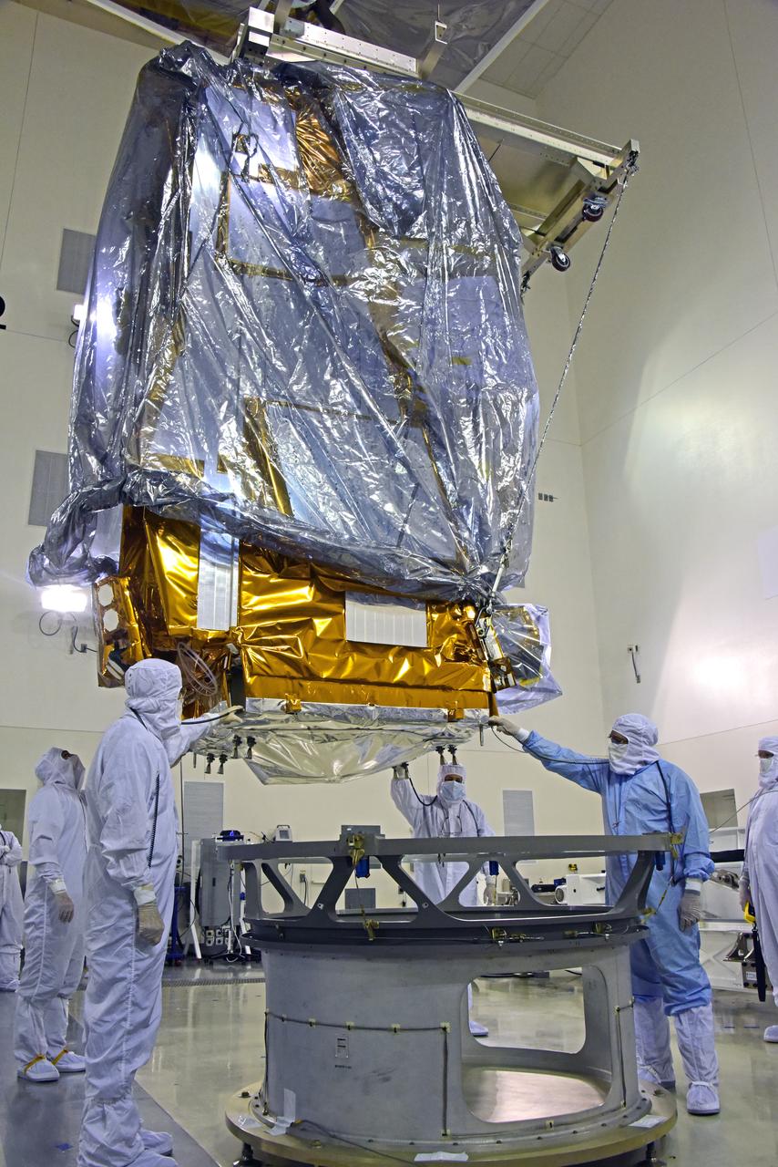 NOAA's Joint Polar Satellite System-1, or JPSS-1, remains wrapped in a protective covering after removal from its shipping container at the Astrotech Processing Facility at Vandenberg Air Force Base in California. Technicians assist as a crane lowers the spacecraft toward a payload attach fitting. JPSS-1 will liftoff aboard a United Launch Alliance Delta II rocket from Vandenberg's Space Launch Complex-2. JPSS-1 is the first in a series of four next-generation environmental satellites in a collaborative program between NOAA and NASA.