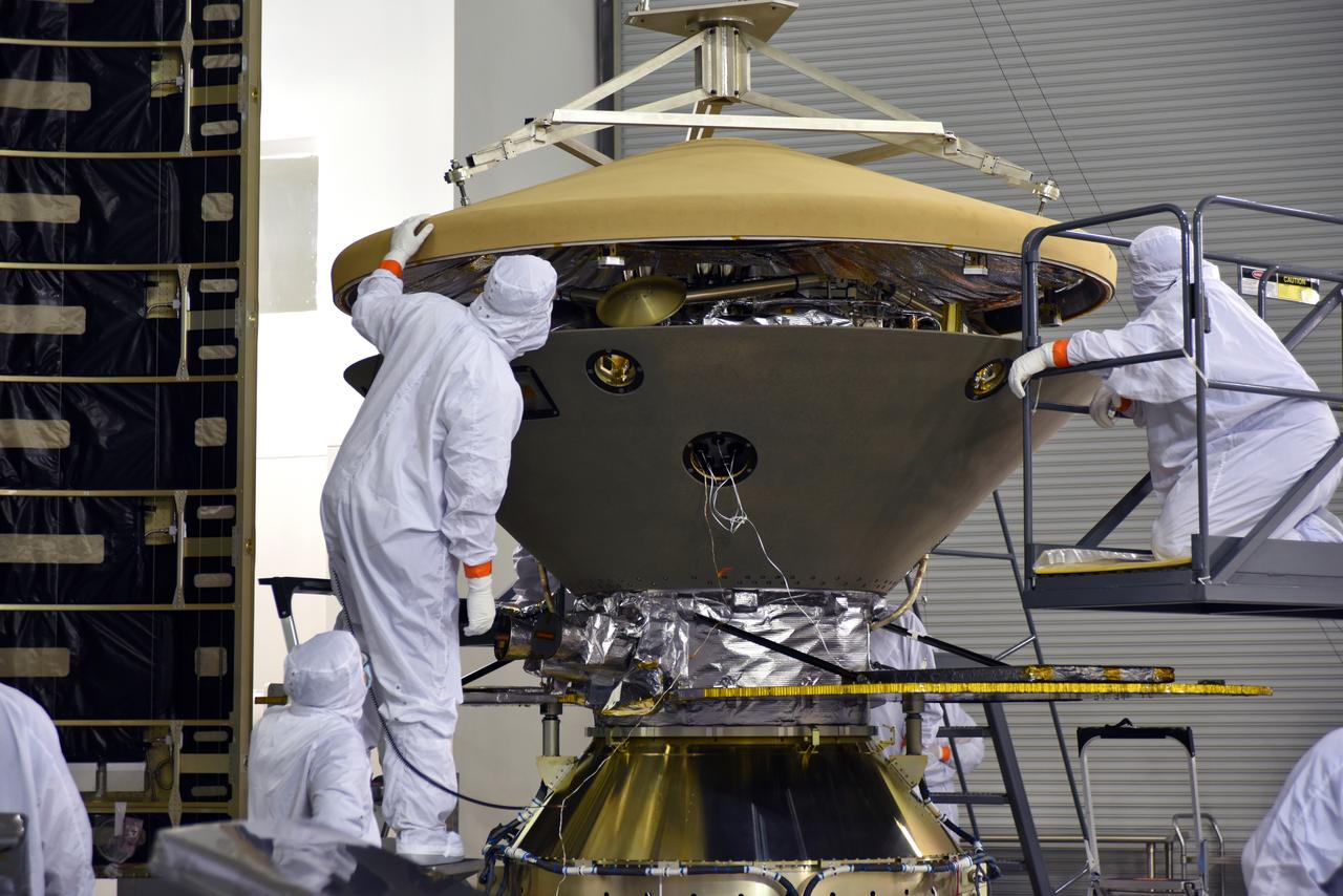 In the Astrotech facility at Vandenberg Air Force Base in California, technicians and engineers place the heatshield on NASA's Interior Exploration using Seismic Investigations, Geodesy and Heat Transport, or InSight, Mars lander prior to encapsulation in its payload fairing. InSight will be the first mission to look deep beneath the Martian surface. It will study the planet's interior by measuring its heat output and listen for marsquakes. The spacecraft will use the seismic waves generated by marsquakes to develop a map of the planet’s deep interior. The resulting insight into Mars’ formation will provide a better understanding of how other rocky planets, including Earth, were created. InSight is scheduled for liftoff May 5, 2018.