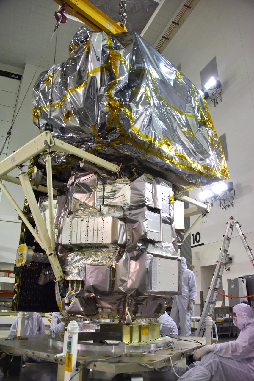 Technicians assist as a crane lowers NASA's Ice, Cloud and land Elevation Satellite-2 (ICESat-2) onto a work stand in the high bay of the Astrotech Space Operations facility on June 14, 2018, at Vandenberg Air Force Base in California. ICESat-2 was shipped from the Northrop Grumman facility in Gilbert, Arizona, where it was built and tested. The satellite is scheduled to launch from Space Launch Complex-2 at Vandenberg on the final United Launch Alliance Delta II rocket. ICESat-2 will measure the height of a changing Earth, one laser pulse at a time, 10,000 laser pulses a second. The satellite will carry the Advanced Topographic Laser Altimeter System. ICESat-2 will help scientists investigate why, and how much our planet's frozen and icy areas, called the cryosphere, is changing in a warming climate.