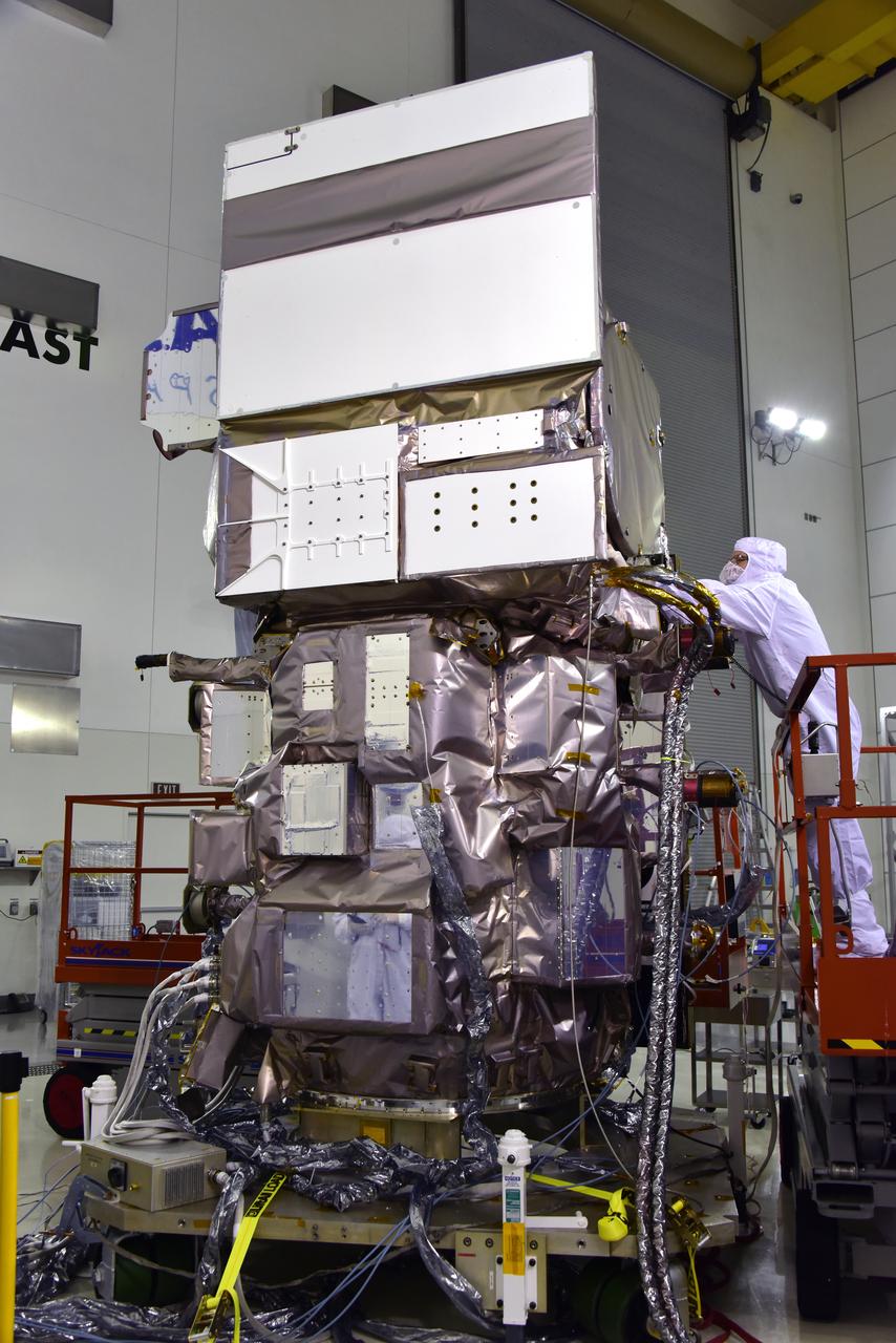 Inside the high bay of the Astrotech Space Operations facility at Vandenberg Air Force Base in California, a technician checks the flight door for the Advanced Topographic Laser Altimeter System (ATLAS) on NASA's Ice, Cloud and land Elevation Satellite-2 (ICESat-2) on June 21, 2018. The satellite is being prepared for its scheduled launch from Space Launch Complex-2 at Vandenberg on the final United Launch Alliance Delta II rocket. ICESat-2 will measure the height of a changing Earth, one laser pulse at a time, 10,000 laser pulses a second. The satellite will carry ATLAS. ICESat-2 will help scientists investigate why, and how much our planet's frozen and icy areas, called the cryosphere, is changing in a warming climate.