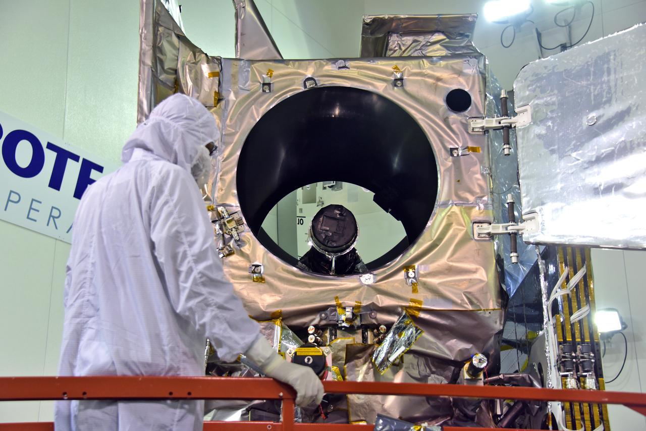 Inside the high bay of the Astrotech Space Operations facility at Vandenberg Air Force Base in California, a technician opens and checks the flight door for the Advanced Topographic Laser Altimeter System (ATLAS) on NASA's Ice, Cloud and land Elevation Satellite-2 (ICESat-2) on June 21, 2018. The satellite is being prepared for its scheduled launch from Space Launch Complex-2 at Vandenberg on the final United Launch Alliance Delta II rocket. ICESat-2 will measure the height of a changing Earth, one laser pulse at a time, 10,000 laser pulses a second. The satellite will carry ATLAS. ICESat-2 will help scientists investigate why, and how much our planet's frozen and icy areas, called the cryosphere, is changing in a warming climate.