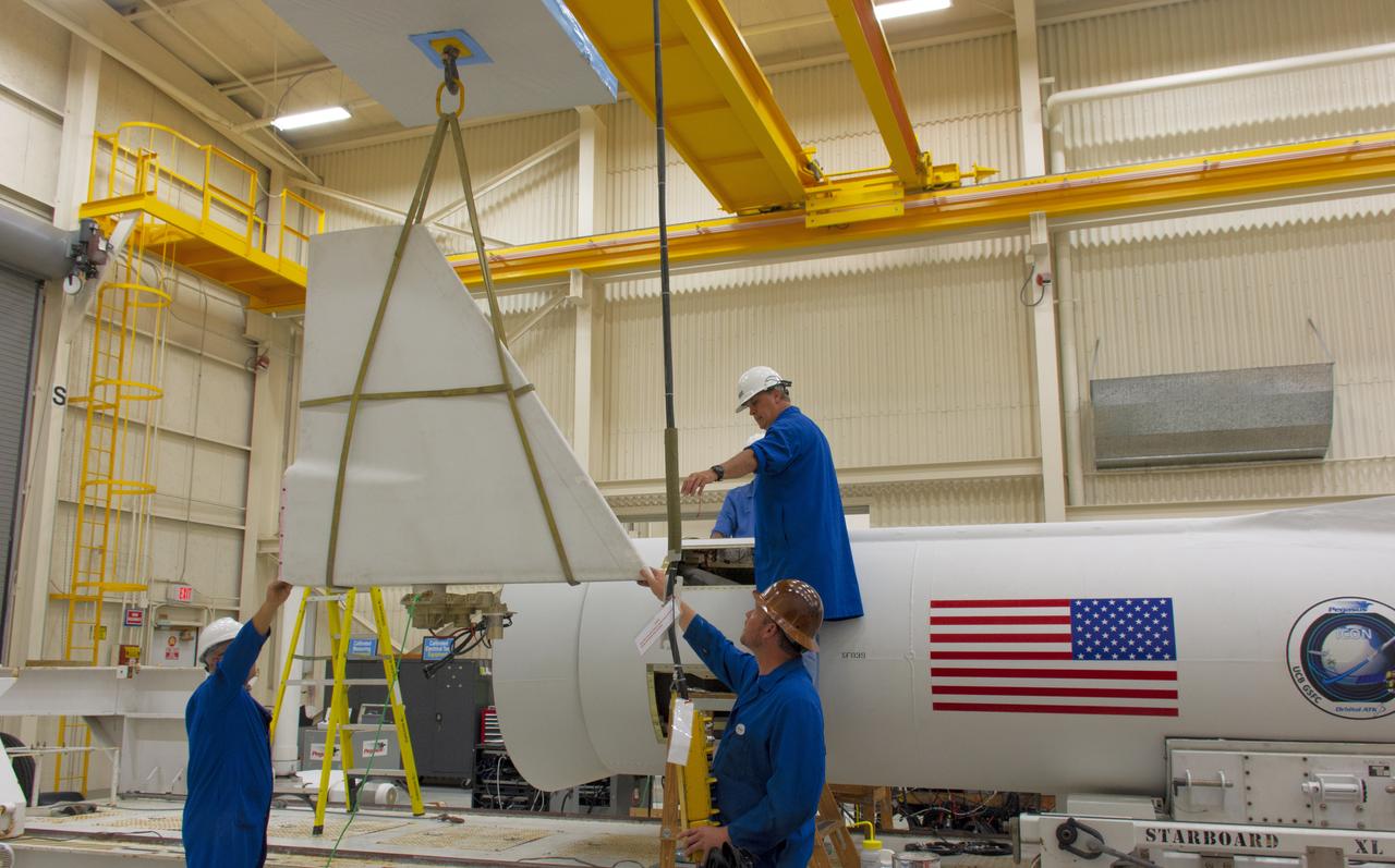 Inside Building 1555 at Vandenberg Air Force Base in California, technicians prepare to install the first of two fins on Northrop Grumman's Pegasus XL rocket on July 30, 2018. The Pegasus XL rocket, attached beneath the company's L-1011 Stargazer aircraft, will launch NASA's Ionospheric Connection Explorer (ICON) from the Skid Strip at Cape Canaveral Air Force Station in Florida. Launch is scheduled for Oct. 26. ICON will study the frontier of space - the dynamic zone high in Earth's atmosphere where terrestrial weather from below meets space weather above. The explorer will help determine the physics of Earth's space environment and pave the way for mitigating its effects on our technology, communications systems and society.
