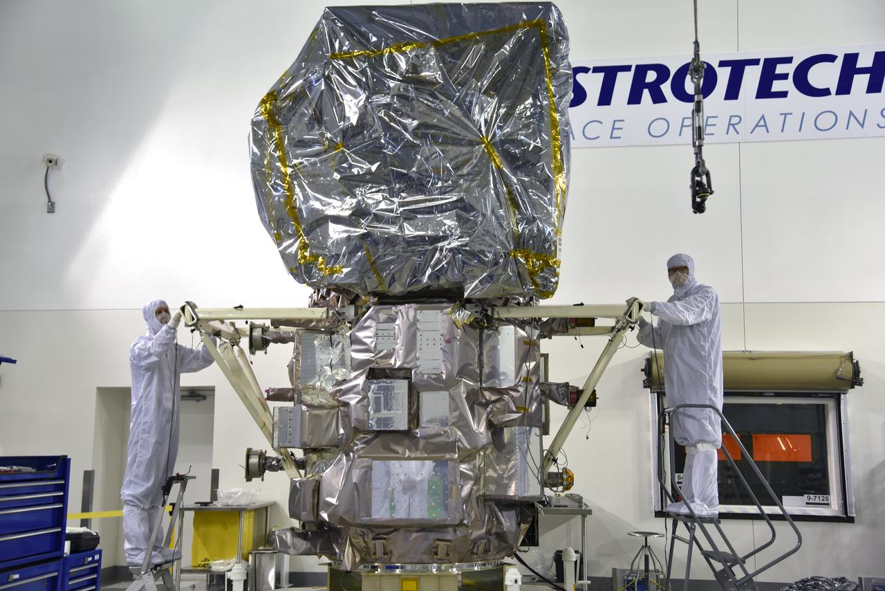 Inside the high bay of the Astrotech Space Operations facility at Vandenberg Air Force Base in California, technicians prepare to attach NASA's Ice, Cloud and land Elevation Satellite-2 (ICESat-2) to the payload adapter, on Aug. 20, 2018. The satellite is being prepared for its scheduled launch from Space Launch Complex 2 at Vandenberg on the final United Launch Alliance Delta II rocket. ICESat-2 will measure the height of a changing Earth, one laser pulse at a time, 10,000 laser pulses a second. The satellite will carry the Advanced Topographic Laser Altimeter System (ATLAS). ICESat-2 will help scientists investigate why, and how much our planet's frozen and icy areas, called the cryosphere, are changing in a warming climate.