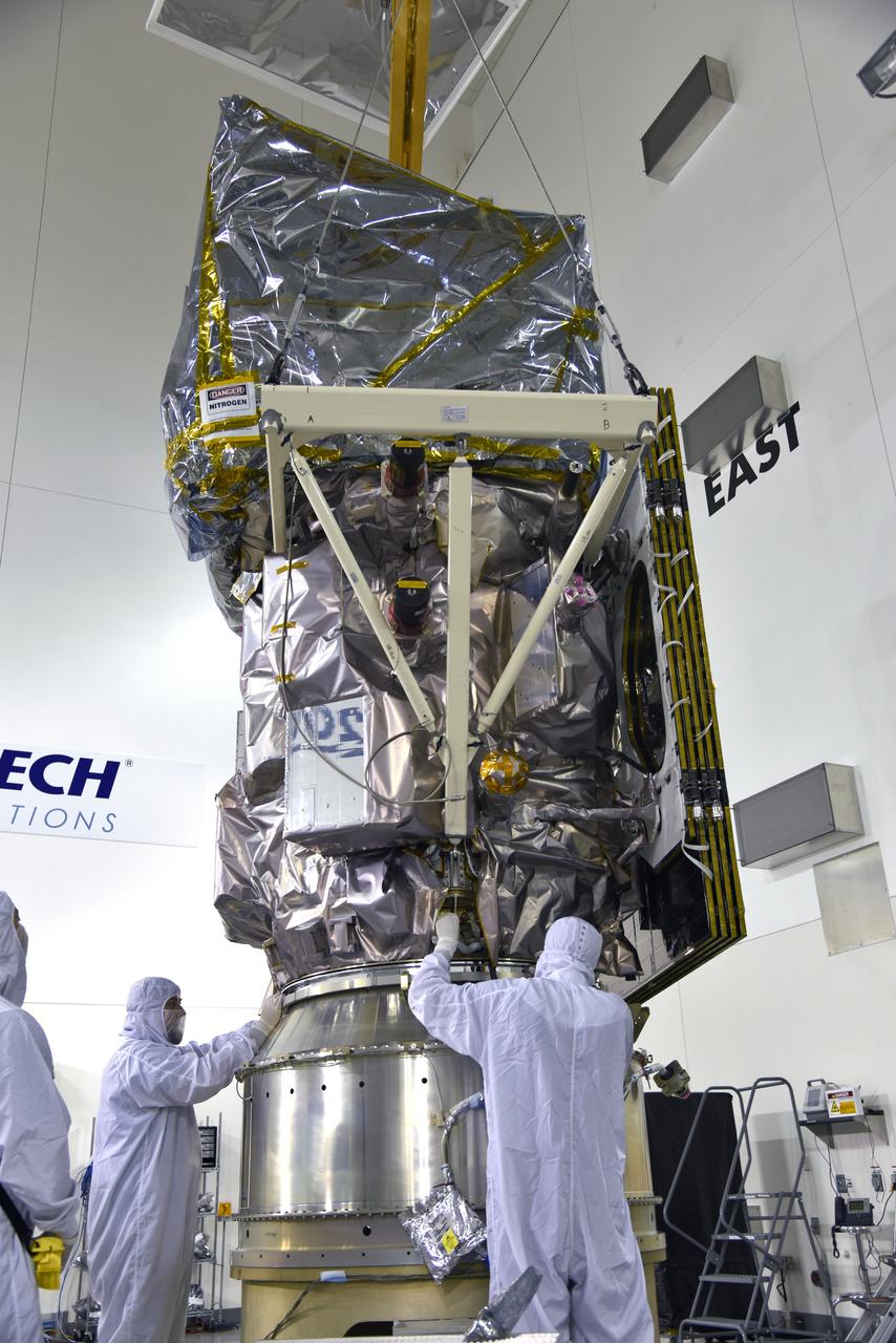 Inside the high bay of the Astrotech Space Operations facility at Vandenberg Air Force Base in California, technicians help secure NASA's Ice, Cloud and land Elevation Satellite-2 (ICESat-2) to the payload adapter on Aug. 30, 2018. ICESat-2 is being prepared for its scheduled launch from Space Launch Complex 2 at Vandenberg on the final United Launch Alliance Delta II rocket. ICESat-2 will measure the height of a changing Earth, one laser pulse at a time, 10,000 laser pulses a second. The satellite will carry the Advanced Topographic Laser Altimeter System (ATLAS). ICESat-2 will help scientists investigate why, and how much our planet's frozen and icy areas, called the cryosphere, are changing in a warming climate.