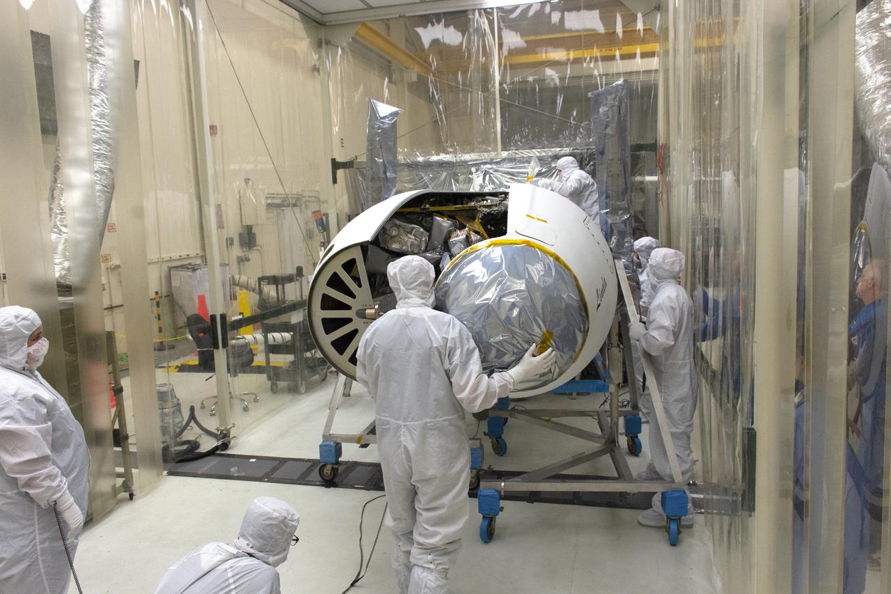 Technicians install the Northrop Grumman Pegasus XL payload fairings around NASA's Ionospheric Connection Explorer (ICON) inside Building 1555 at Vandenberg Air Force Base in California, on Aug. 22, 2018. The Pegasus XL rocket, attached beneath the company's L-1011 Stargazer aircraft, will launch ICON from the Skid Strip at Cape Canaveral Air Force Station in Florida. Launch is scheduled for Oct. 26. ICON will study the frontier of space - the dynamic zone high in Earth's atmosphere where terrestrial weather from below meets space weather above. The explorer will help determine the physics of Earth's space environment and pave the way for mitigating its effects on our technology and communications systems.