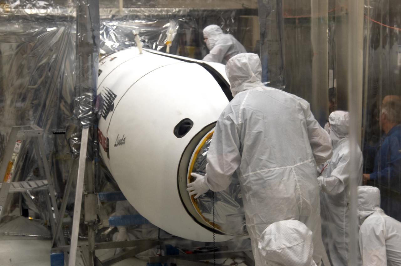 Inside a clean room in Building 1555 at Vandenberg Air Force Base in California, technicians complete installation of the Northrop Grumman Pegasus XL port and starboard payload fairings around NASA's Ionospheric Connection Explorer (ICON) on Aug. 22, 2018. ICON is being prepared for its launch on the Pegasus XL rocket, which is attached beneath the company's L-1011 Stargazer aircraft. Launch is scheduled for Oct. 26, from the Skid Strip at Cape Canaveral Air Force Station in Florida. ICON will study the frontier of space - the dynamic zone high in Earth's atmosphere where terrestrial weather from below meets space weather above. The explorer will help determine the physics of Earth's space environment and pave the way for mitigating its effects on our technology, communications systems and society.