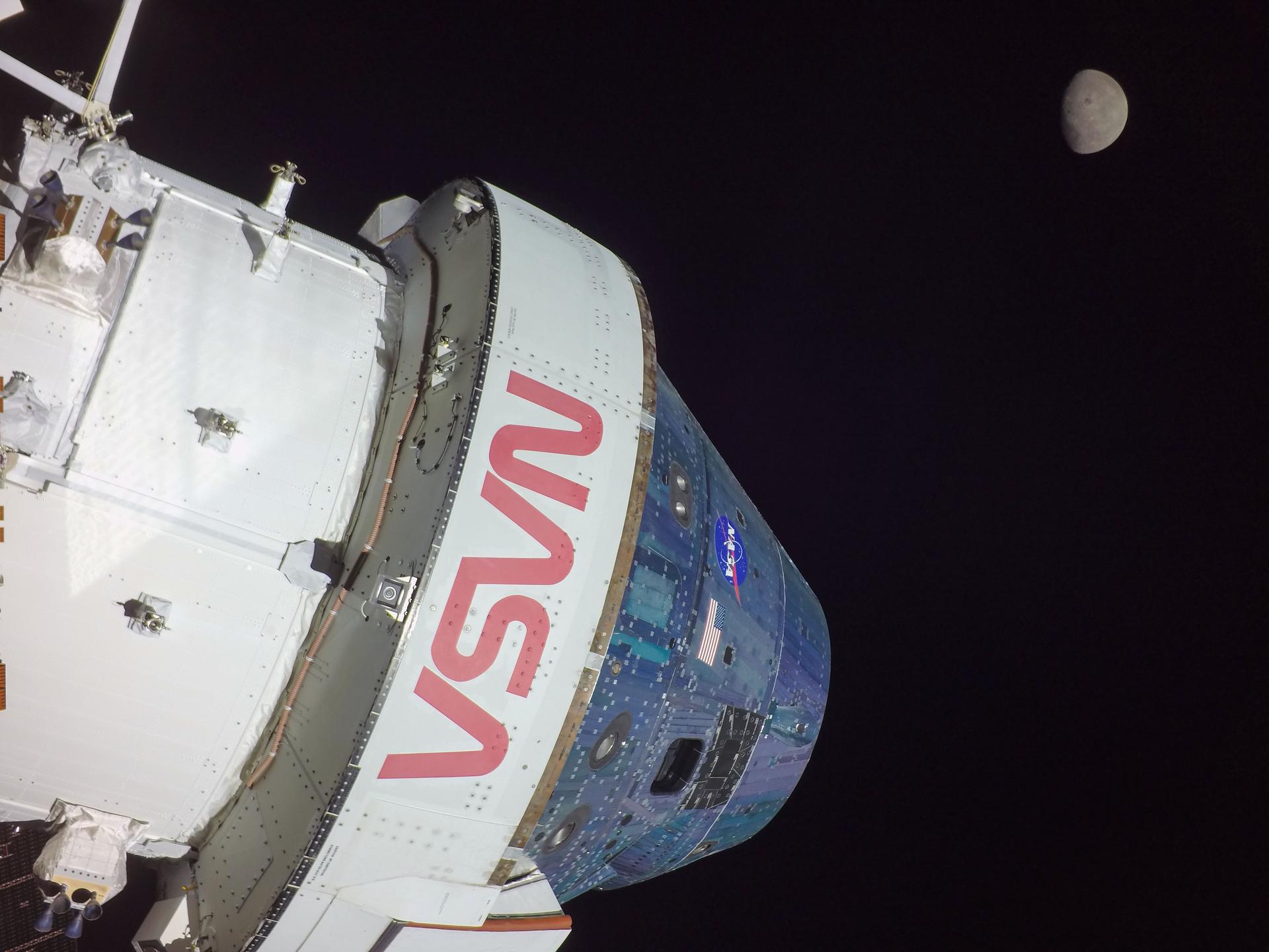 The Orion spacecraft in flight with the Moon visible in the distance
