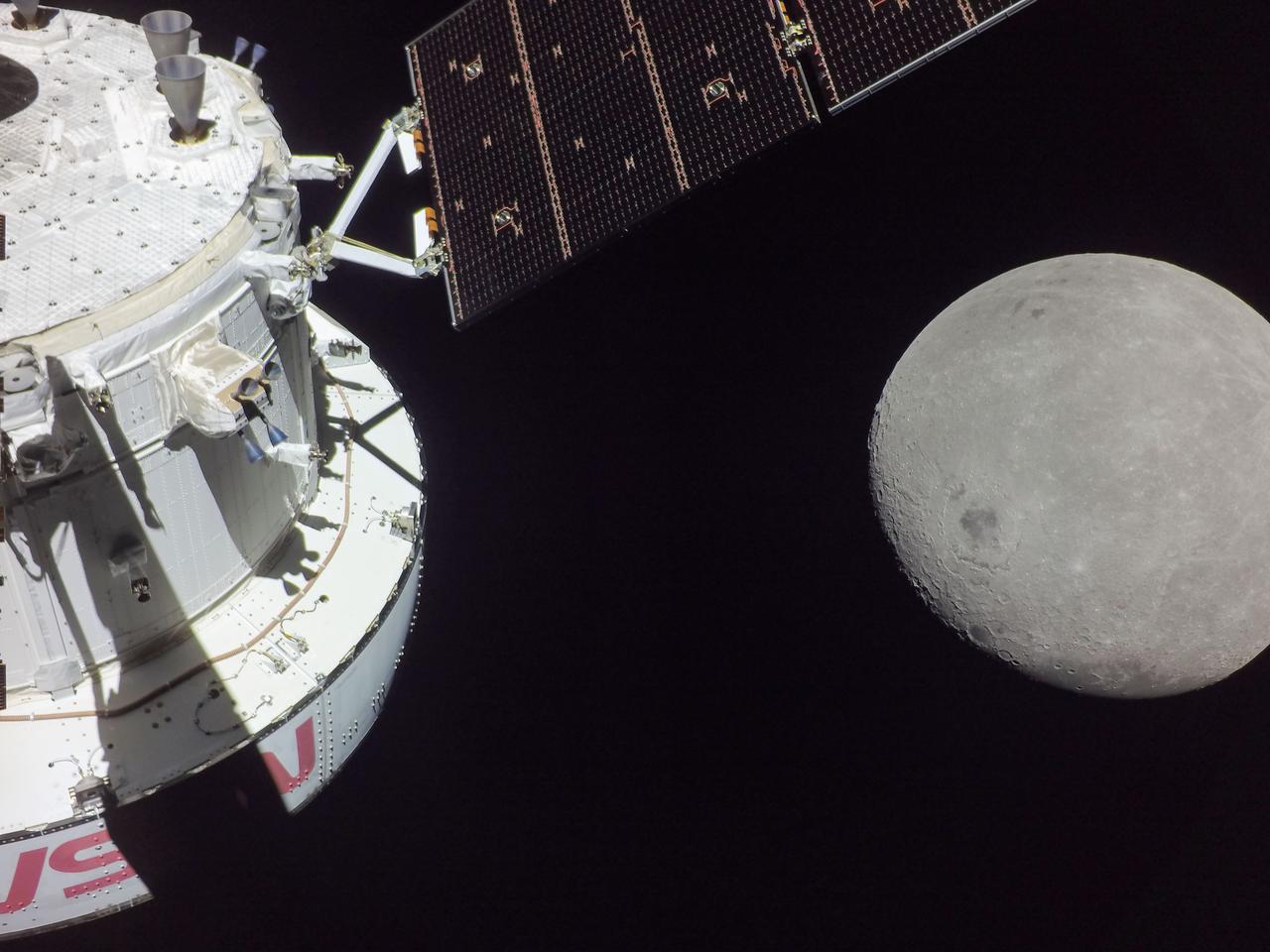 (Nov. 21, 2022) A portion of the Moon looms large just beyond the Orion spacecraft in this image taken on the sixth day of the Artemis I mission by a camera on the tip of one of Orion’s solar arrays. The spacecraft entered the lunar sphere of influence Sunday, Nov. 20, making the Moon, instead of Earth, the main gravitational force acting on the spacecraft. On Monday,  Nov. 21, it came within 80 miles of the lunar surface, the closest approach of the uncrewed Artemis I mission, before moving into a distant retrograde orbit around the Moon. The darkest spot visible near the middle of the image is Mare Orientale.