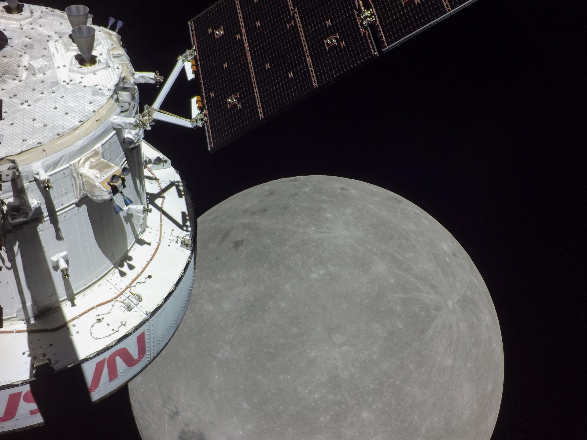 A portion of the Moon looms large just beyond the Orion spacecraft in this image taken on the sixth day of the Artemis I mission by a camera on the tip of one of Orion’s solar arrays.