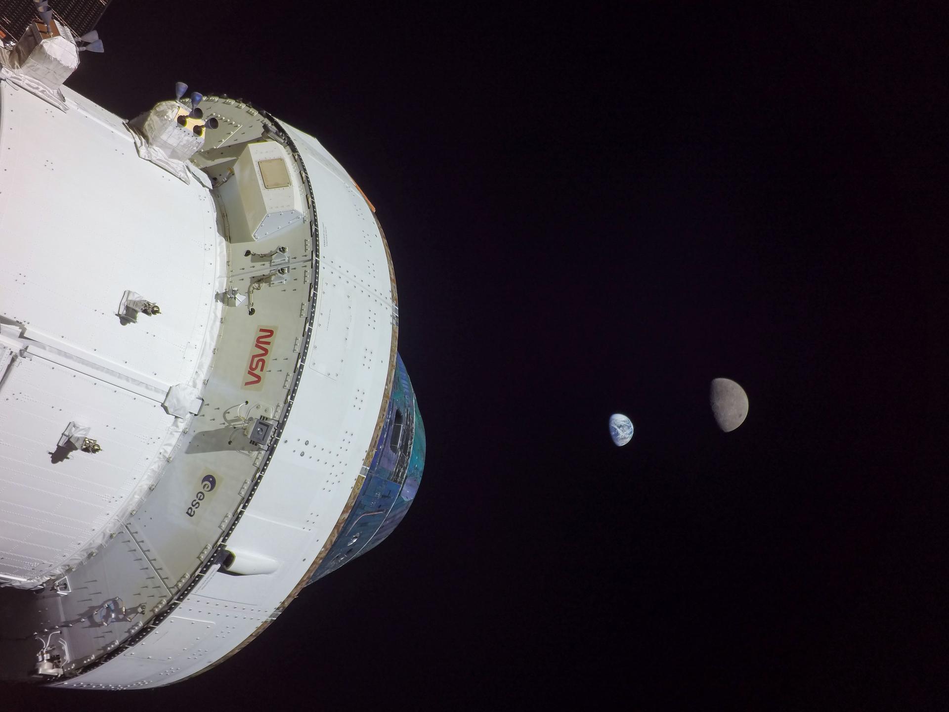 Orion in space with the Earth and Earth's moon shown in the background