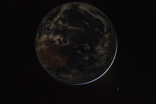 A view of a backlit Earth taken by NASA astronaut and Artemis...