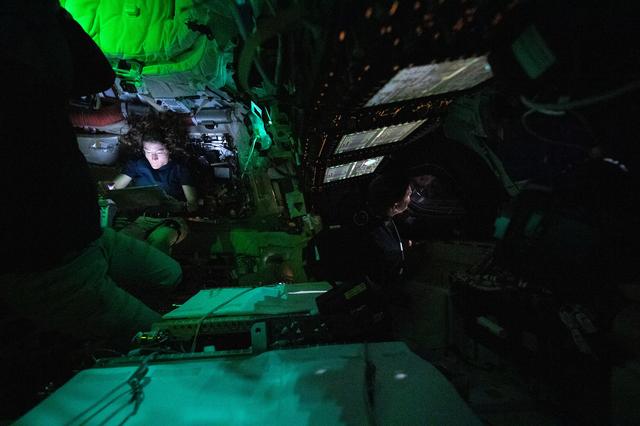NASA astronaut Christina Koch is illuminated by a screen...