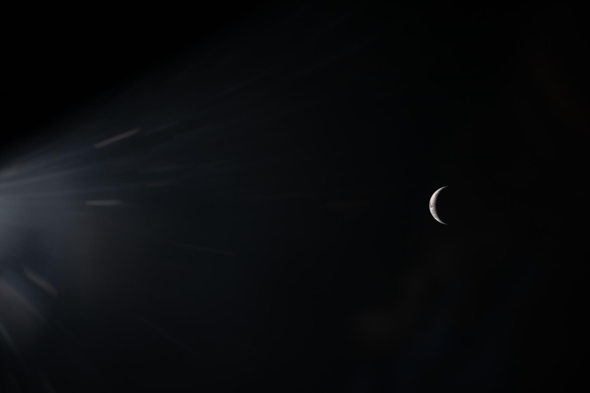 art002e00444 (April 3, 2026) - An illuminated sliver of Earth set against the blackness of space is seen through the...